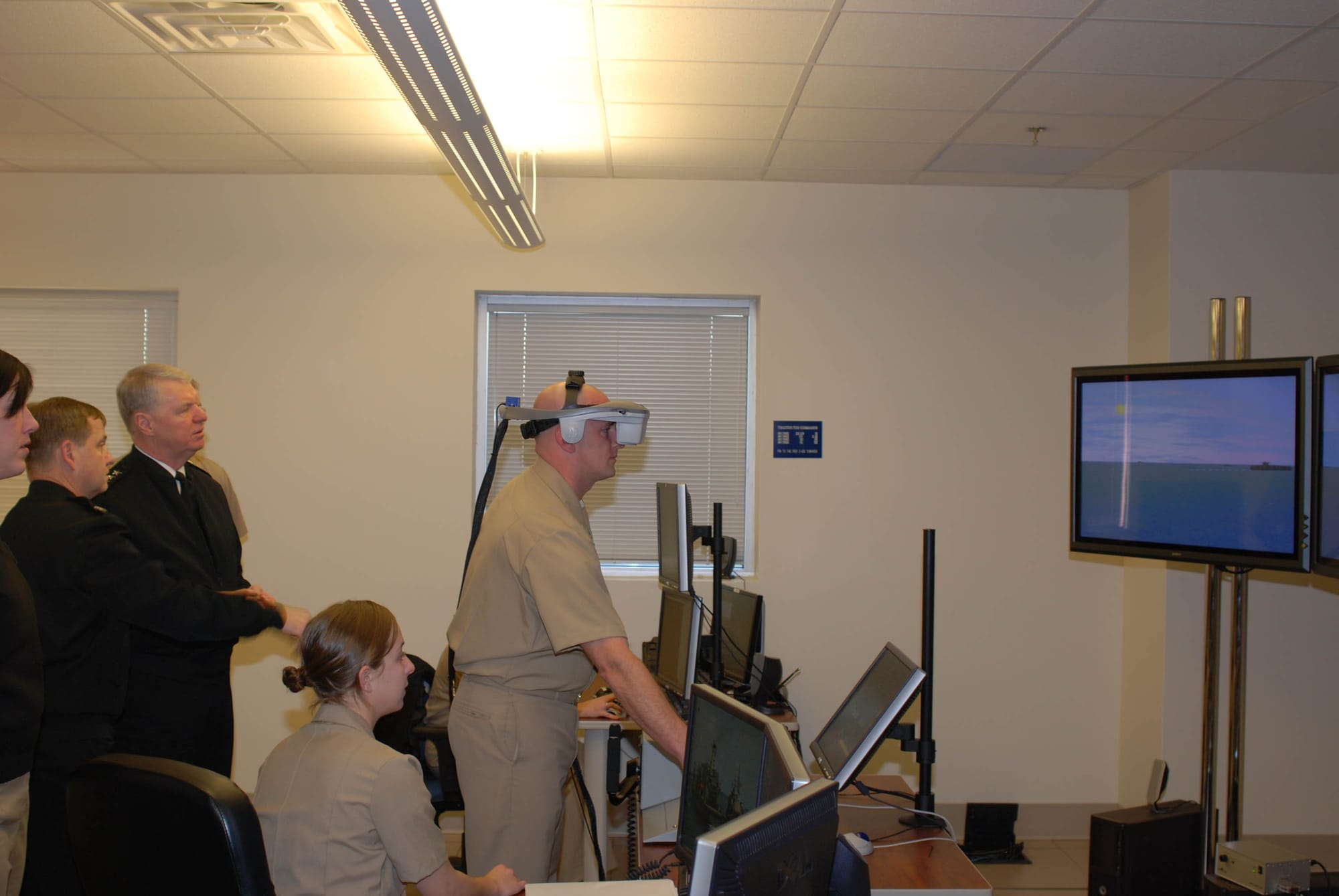 Chief of Naval Operations Adm. Gary Roughead tries a Conning Officer Virtual Environment simulator at the Surface Warfare Officers School as students from the Advanced Shiphandling and Tactics course conduct a Strait of Hormuz tactical scenario. Roughead was in Newport to visit with the Surface Warfare Officer School, Naval War College, Strategic Studies Group, and Command Leadership School..