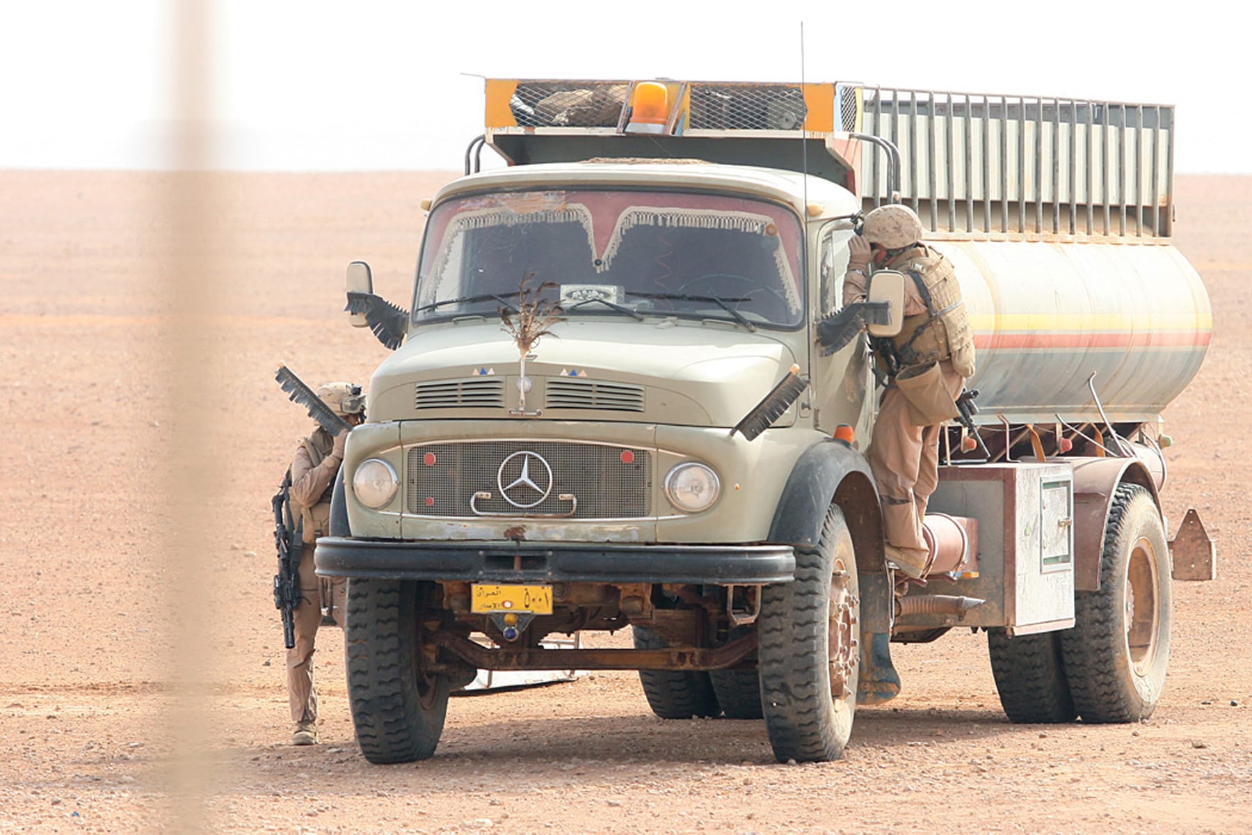 Marines search a tanker truck left in the middle of the desert. The company swept through the valley in the western Anbar Province searching for insurgents, weapons, and illegal material during Operation Mawtini III.