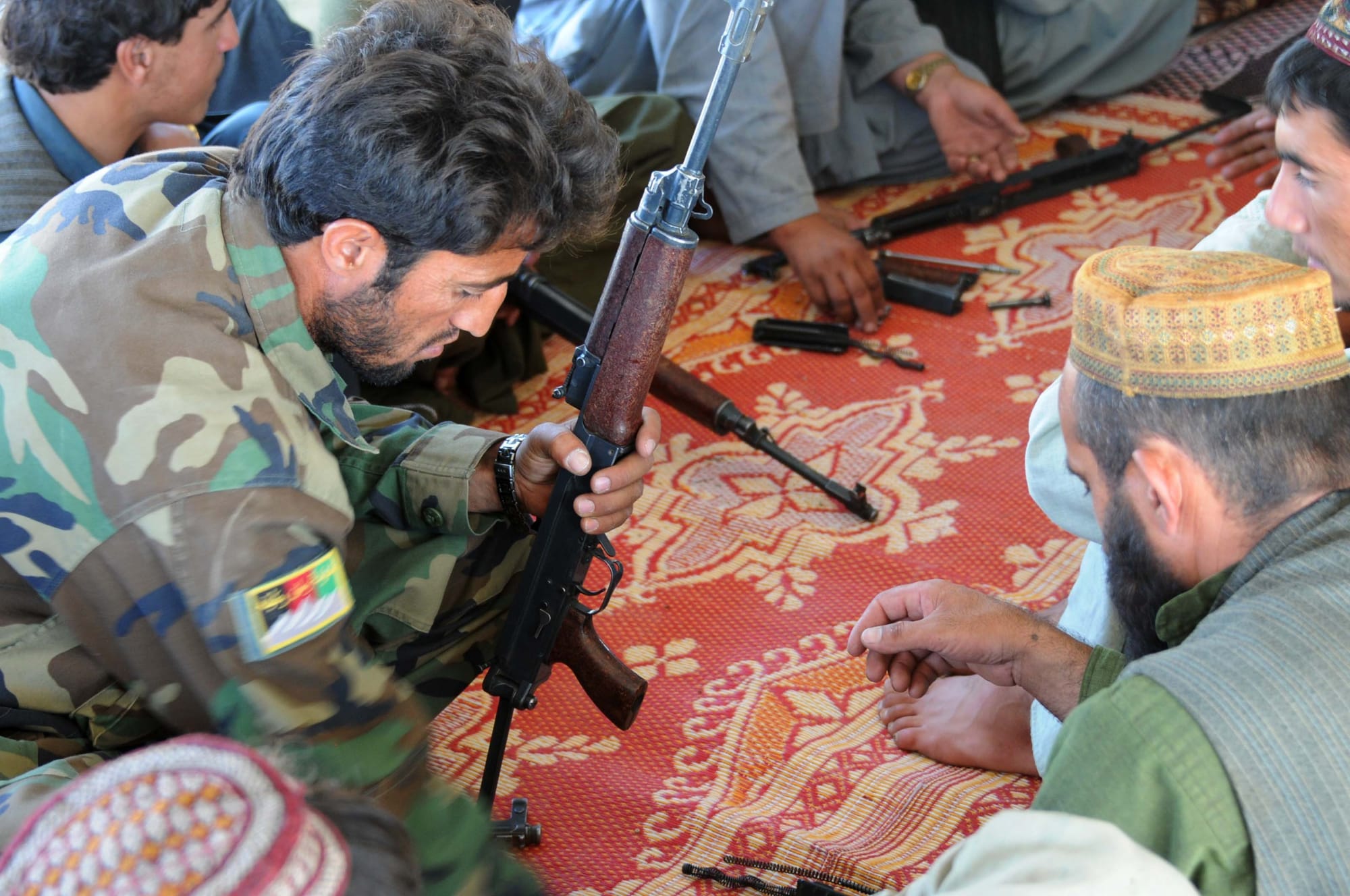 Afghans training to be members of the Afghan Local Police receive weapons training from a member of the Afghan National Army special forces in the Sha Wali Kot district of southern Afghanistan’s Kandahar province, June 17. The Afghan special forces are trained the villagers on weapons handling and safety as well as the rules of engagement and the use of force.