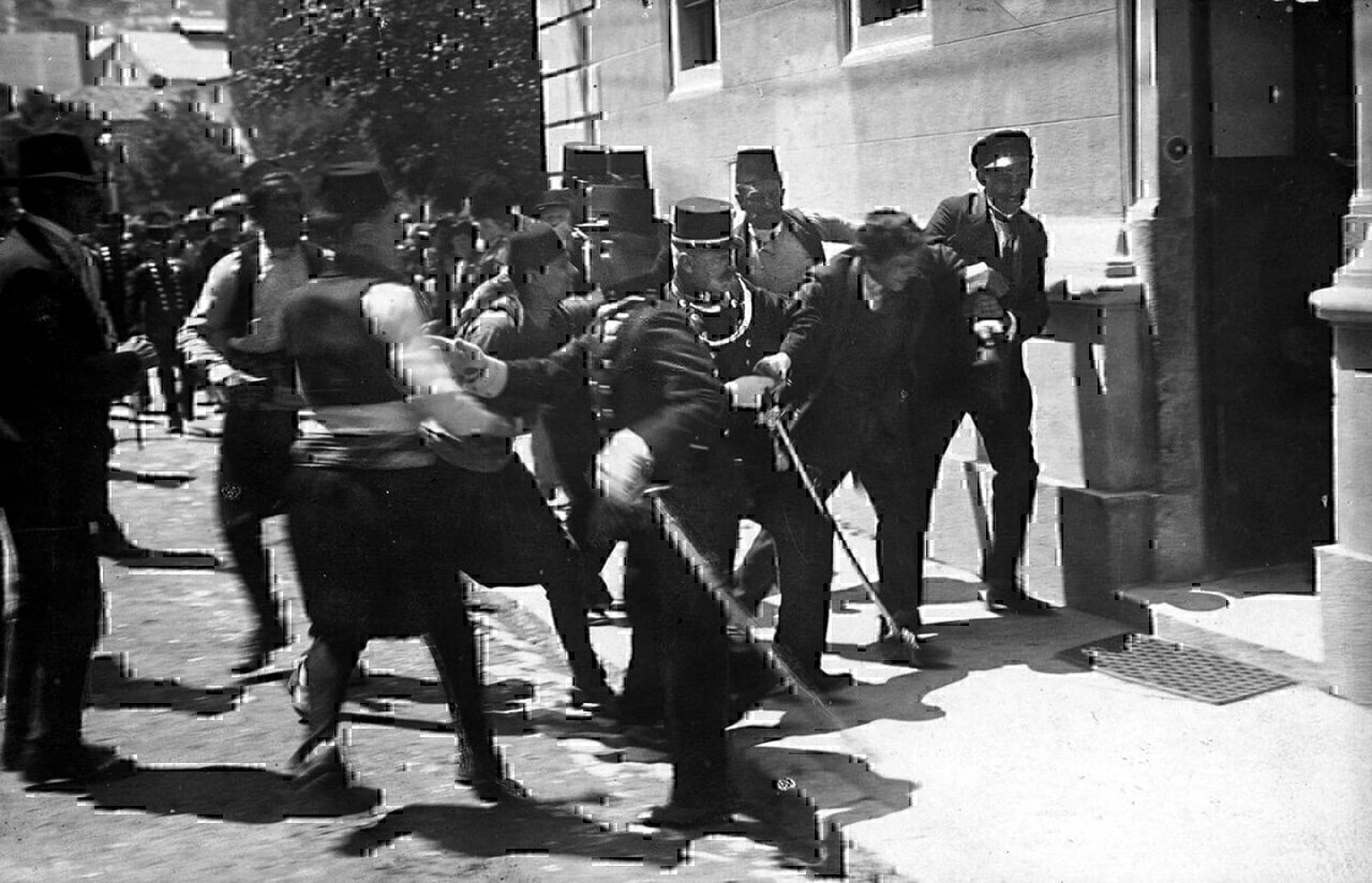 This photograph belongs in the context of the murder of Archduke Franz Ferdinand and his wife. The person arrested in the photograph is an innocent bystander by the name of Ferdinand Behr and not assassin Gavrilo Princip as has been often claimed.