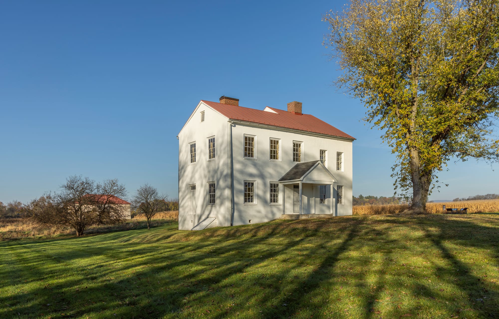 The Best Farm/L’Hermitage Slave Village site, Monocacy National Battlefield, Frederick, Maryland, USA, in early morning shadows. The house is an unusual example of a mixture of the local Federal style and Caribbean French Colonial styles of building and plantation culture, transplanted from Haiti/Saint-Domingue to central Maryland. It was built as the home of the Vincendrière family, who fled Saint-Domingue during the Haitian Revolution, and came to Maryland to establish a version of the plantation culture with which they were familiar. L'Hermitage was one of the largest slave-holding plantations in Maryland, and was notable for its brutal treatment of those enslaved there. The adjacent lands are documented as L'Hermitage Slave Village Archeological Site. The lands were fought over during the Battle of Monocacy in 1864 during the American Civil War. The hip-roofed barn, unusual for Maryland, is seen to the rear.Enoch Louis Lowe, 29th Governor of Maryland, was born at L'Hermitage in 1820, son of Bradley Samuel Adams Lowe and Adelaide Bellumeau de la Vincendrière