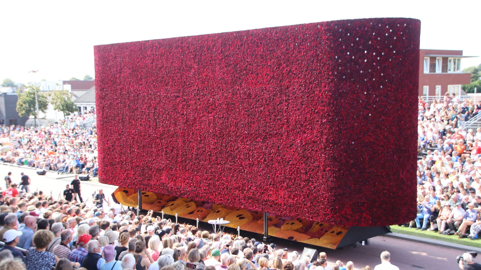 Float of the 2023 flower parade of Zundert from hamlet Molenstraat, titled "8.000.000.000". The float is seemingly something of a black box from the outside, but contains numerous figures inside, that can be seen peeking out from below on the mirrored surface.The float was 14th in the parade. With 558 points awarded, it won 5th place. It also won the "Pluim", a special award for floats with innovative design.The float was designed by Robin Schijfs, Gijs Martens, Ton van Beek and Jesse Verheijen.