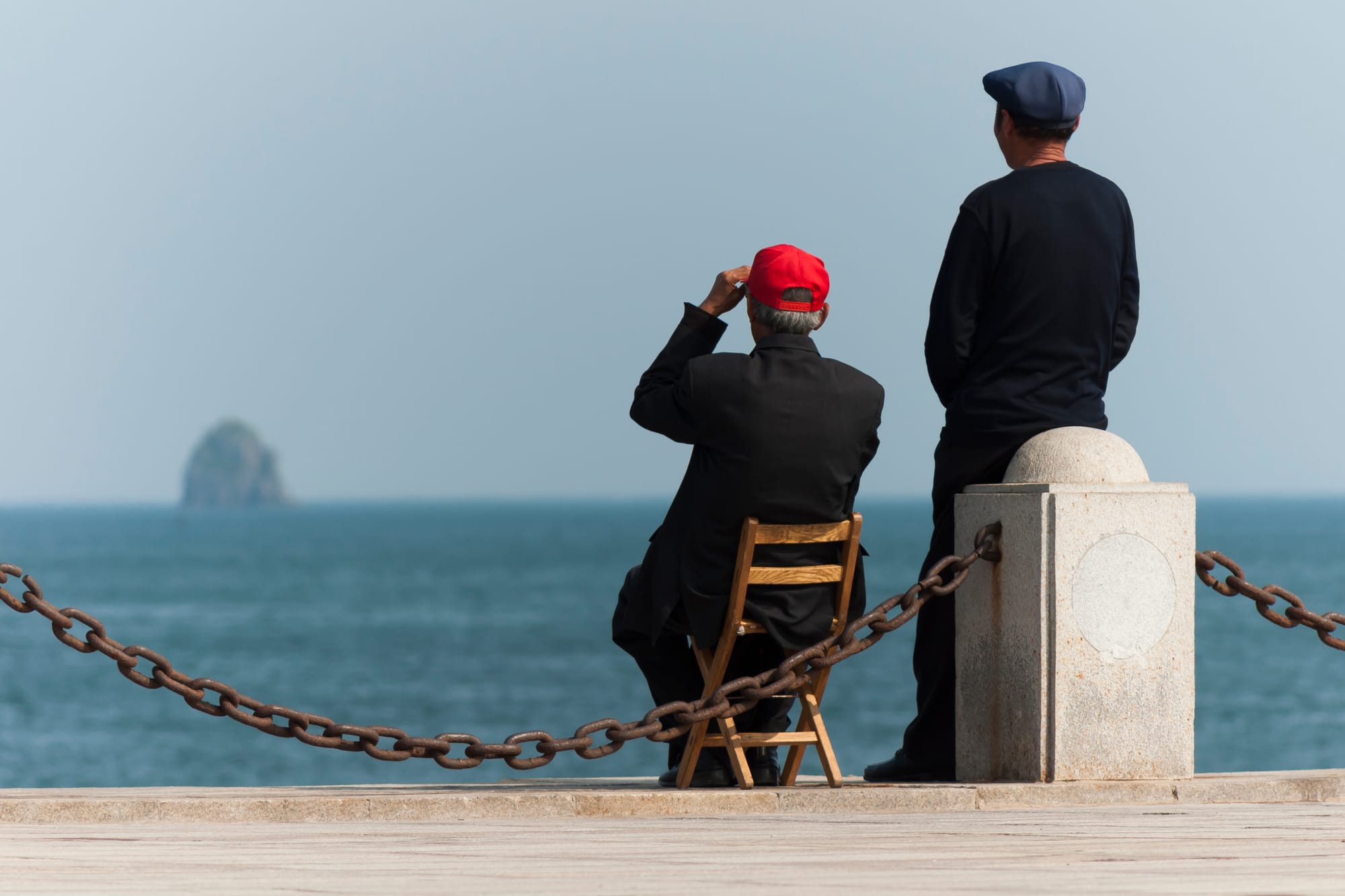 Dalian, Liaoning, China: Two elderly Chinese guys enjoying the sea at Xinghai Bay