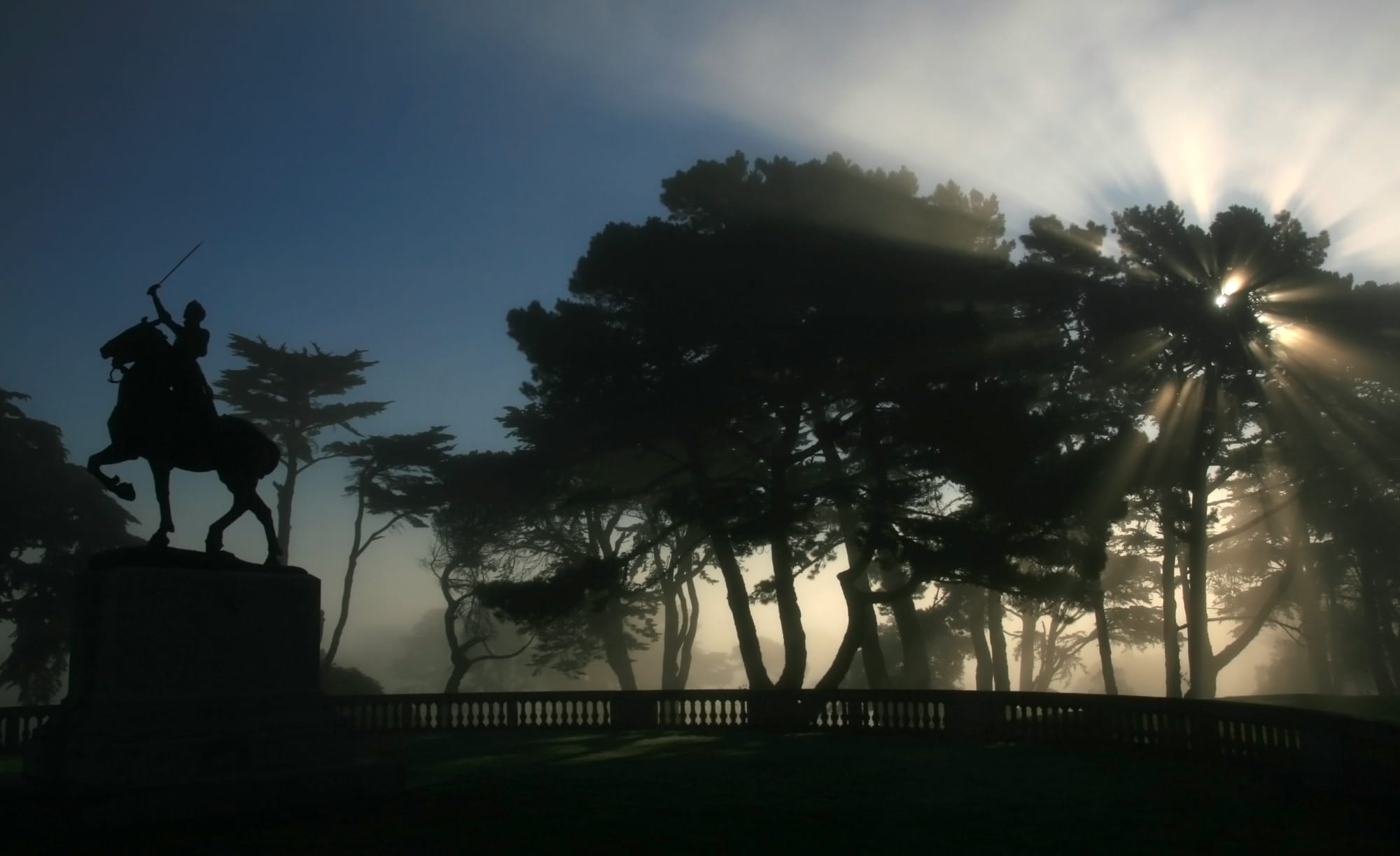 Joan of Arc on horseback, triumphantly raising her sword to the heavens and crepuscular rays at San Francisco's Palace of the Legion of Honor