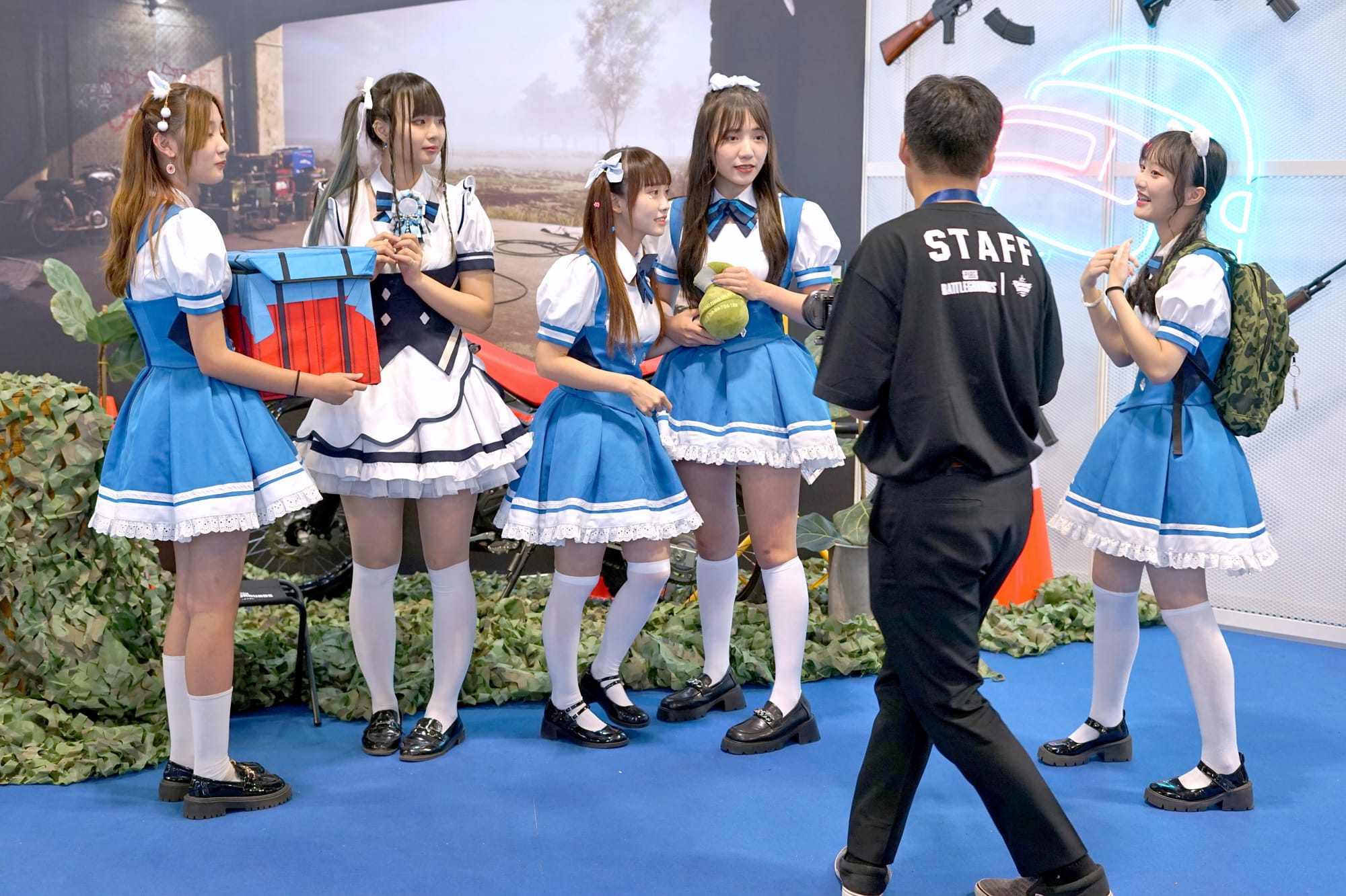 2023夏日電玩展,魁匠團攤位拍照區,Kirabase女僕五人錄製魁匠團攤位官方宣傳片,魁匠團攤位官方攝影師(右二)以數位相機錄影中。