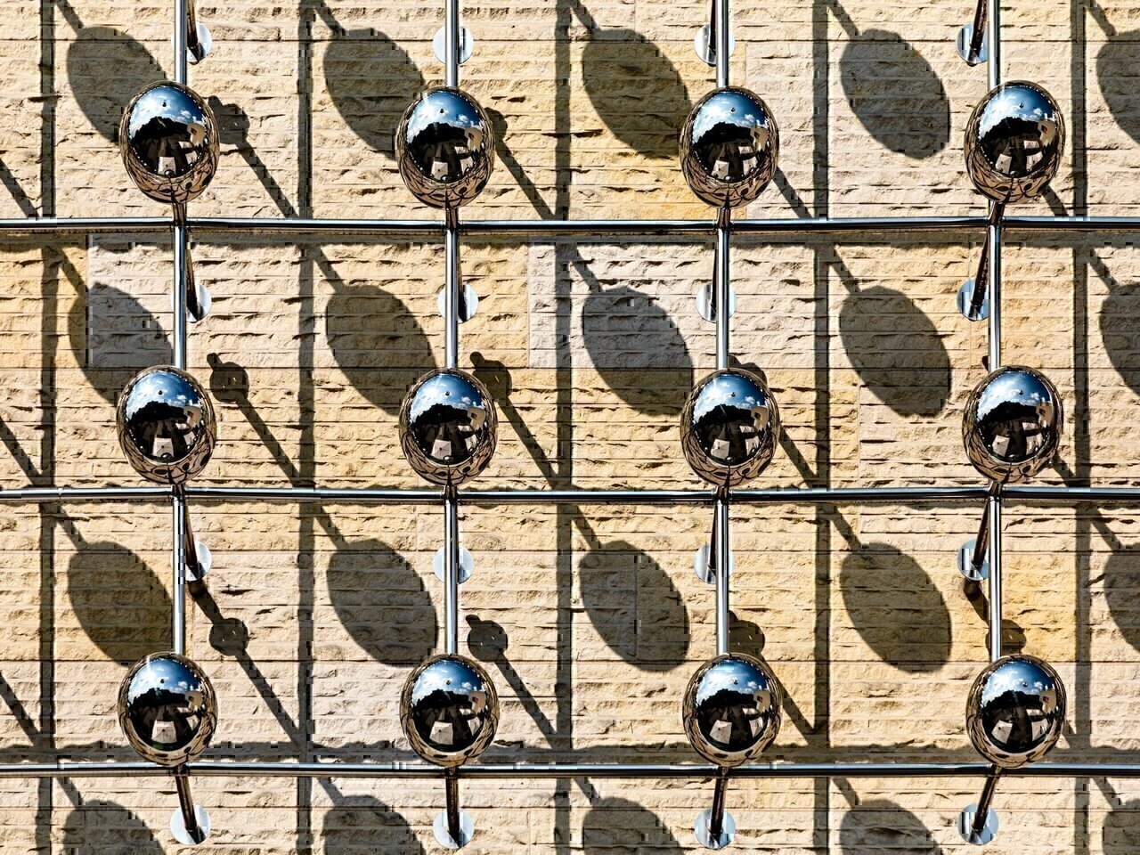 Detail of the sculpture “Silberne Frequenz” (Otto Piene, 1970/71, redesign 2012/14) at the LWL Museum for Art and Culture, Münster, North Rhine-Westphalia, GermanyOtto Piene’s sculpture “Silberne Frequenz” (Silver Frequency) stands in front of the LWL Museum of Art and Culture in Münster. It was installed in 2014 as part of the museum’s renovation and the redesign of the forecourt.Piene, co-founder of the ZERO group, worked with light, movement, and immaterial effects. The sculpture consists of slender, silver-reflecting metal elements that come together to form a dynamic, wave-like shape. Its appearance changes depending on the incidence of light—reflections create the impression of vibration and energy. The title refers to frequencies as a symbol of exchange and communication.In the course of later redesigns of the square, the sculpture’s surroundings were rearranged; the work was preserved, but its effect in the space was slightly altered. The large “LWL” lettering on the forecourt was also discussed in this context. Critics perceived it as promotional and dominant over art and architecture, while supporters saw it as a clear identification of the museum’s location. The debate shows how sensitively the interplay between artwork, architecture, and public space is perceived.