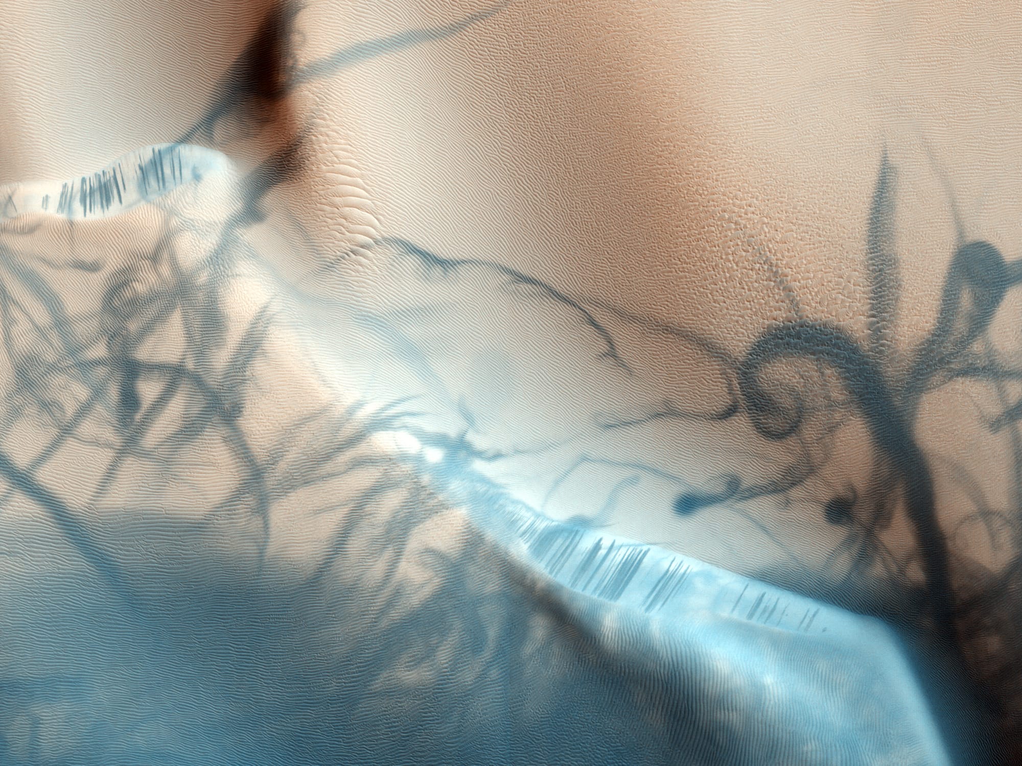 This portion of a recent high-resolution picture from the HiRISE camera on board the Mars Reconnaissance Orbiter shows twisting dark trails criss-crossing light coloured terrain on the Martian surface. Newly formed trails like these had presented researchers with a tantalizing Martian mystery but are now known to be the work of miniature wind vortices known to occur on the red planet - Martian dust devils. Such spinning columns of rising air heated by the warm surface are also common in dry and desert areas on planet Earth. Typically lasting only a few minutes, dust devils becoming visible as they pick up loose red-coloured dust leaving the darker and heavier sand beneath intact. On Mars, dust devils can be up to 8 kilometres high. Dust devils have been credited with unexpected cleanings of Mars rover solar panels.