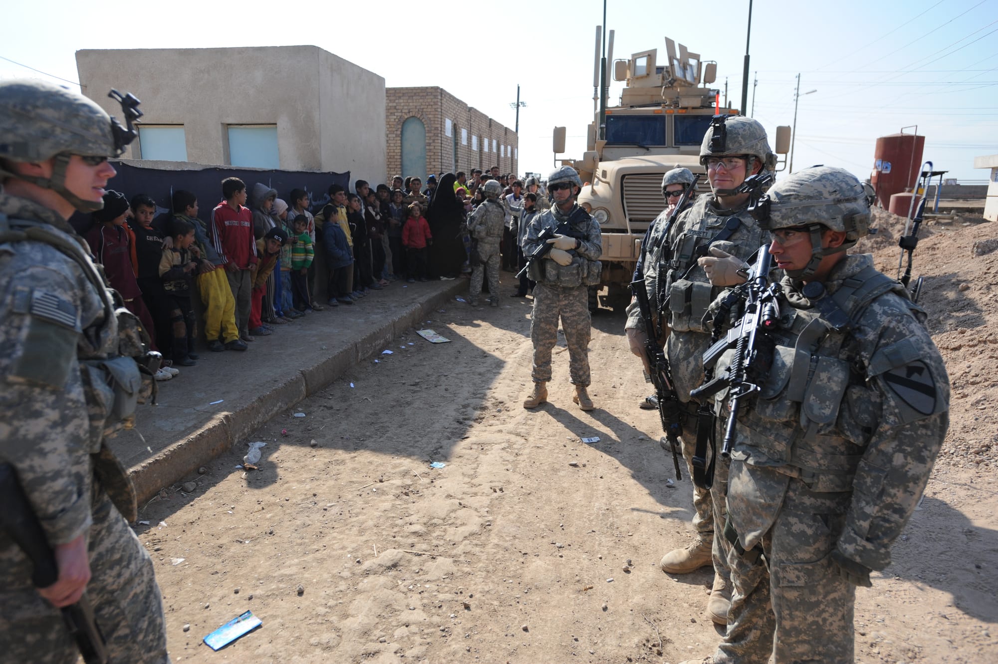 U.S. Cavalrymen from 1st Squadron, 9th Cavalry Regiment, 4th Brigade Combat Team, 1st Cavalry Division, keep order as Iraqi boys from rural Maysan province, Iraq, line up for medical care at the clinic in Beni Hashim. This Civil Military Engagement will bring medical supplies and services to the area, Jan. 25, 2009.