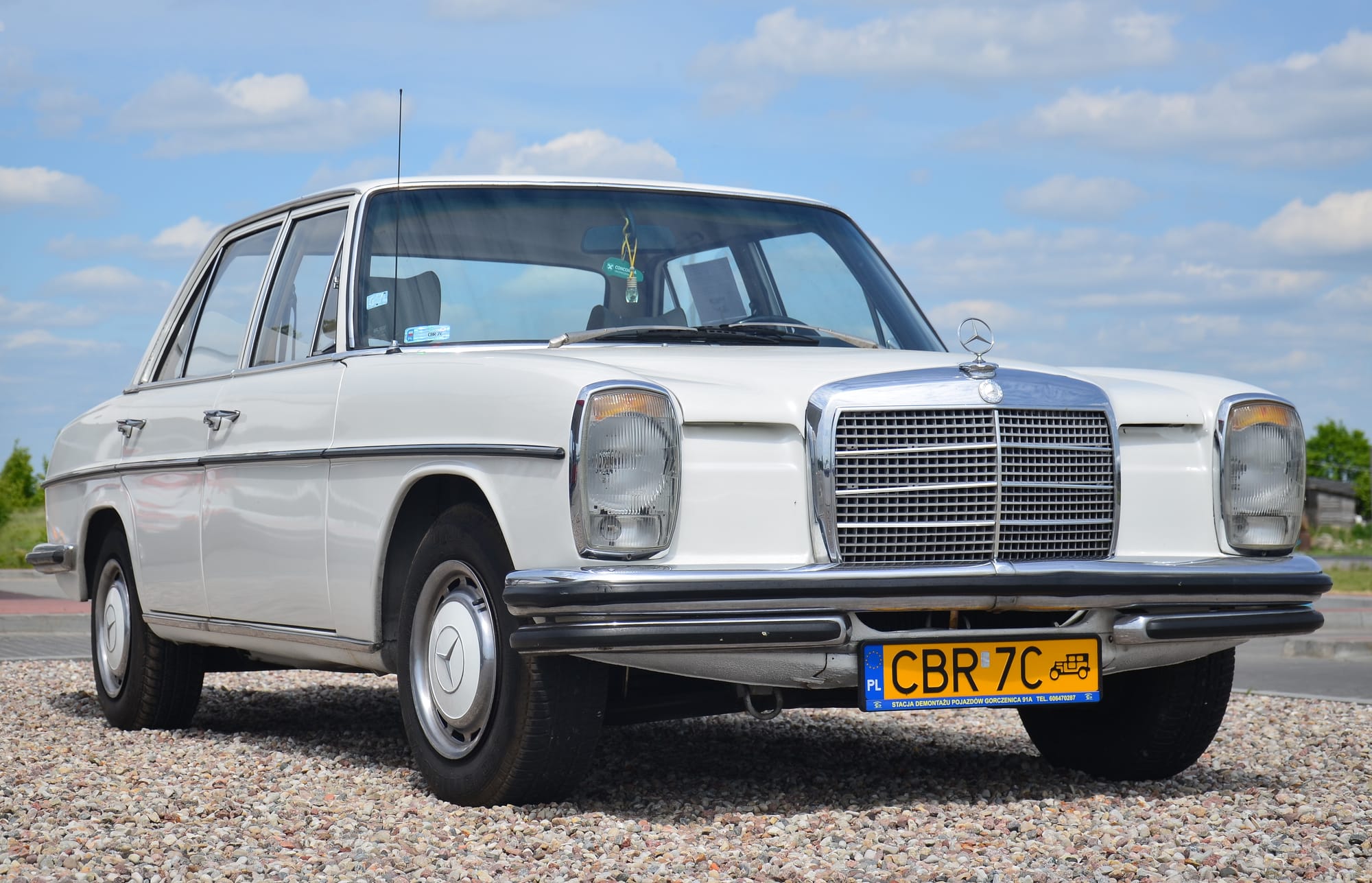 A 1973 model, pre-facelift Mercedes-Benz W115 220D photographed near Gorczenica, Poland. All W115 models feature four-cylinder engines with the 220D version having a 2.2 L diesel engine.
