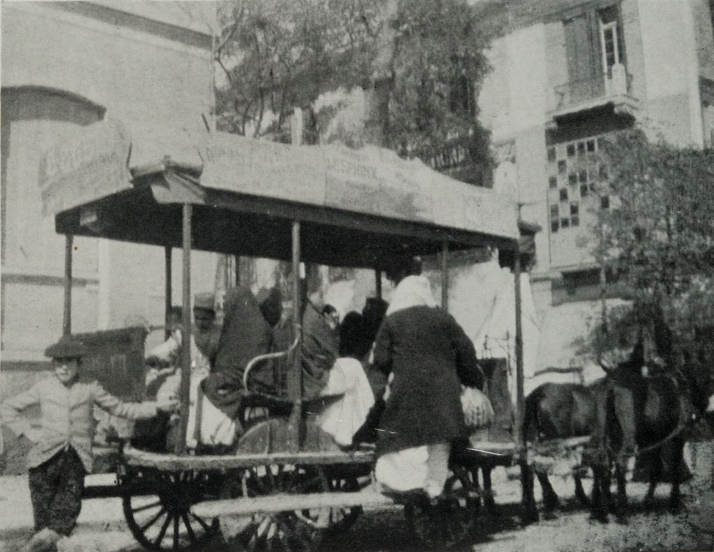NATIVE ’BUS OF THE MORE REFINED KIND, DRAWN BY TWO ASSES, IN THE ATABA-EL-KHADRA.Men and women getting into a cart. Black-and-white photograph.