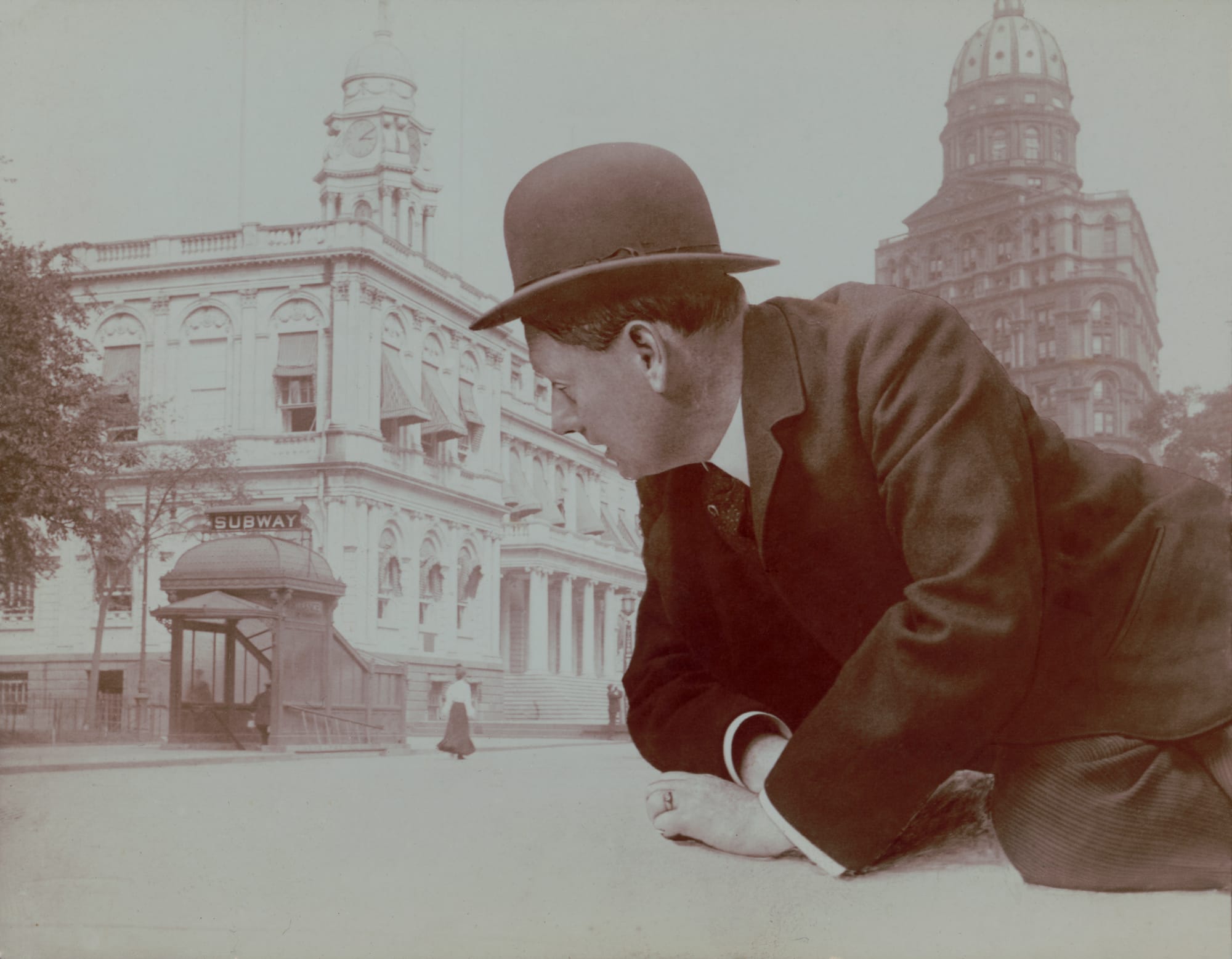 Title: Reclining man looming over New York City subway station
Abstract/medium: 1 photograph&nbsp;: gelatin silver print&nbsp;; sheet 16 x 11 cm.Montage photograph shows gigantic man in suit and bowler hat superimposed reclining in front of New York City Hall Subway Station and the New York World building behind him on right.