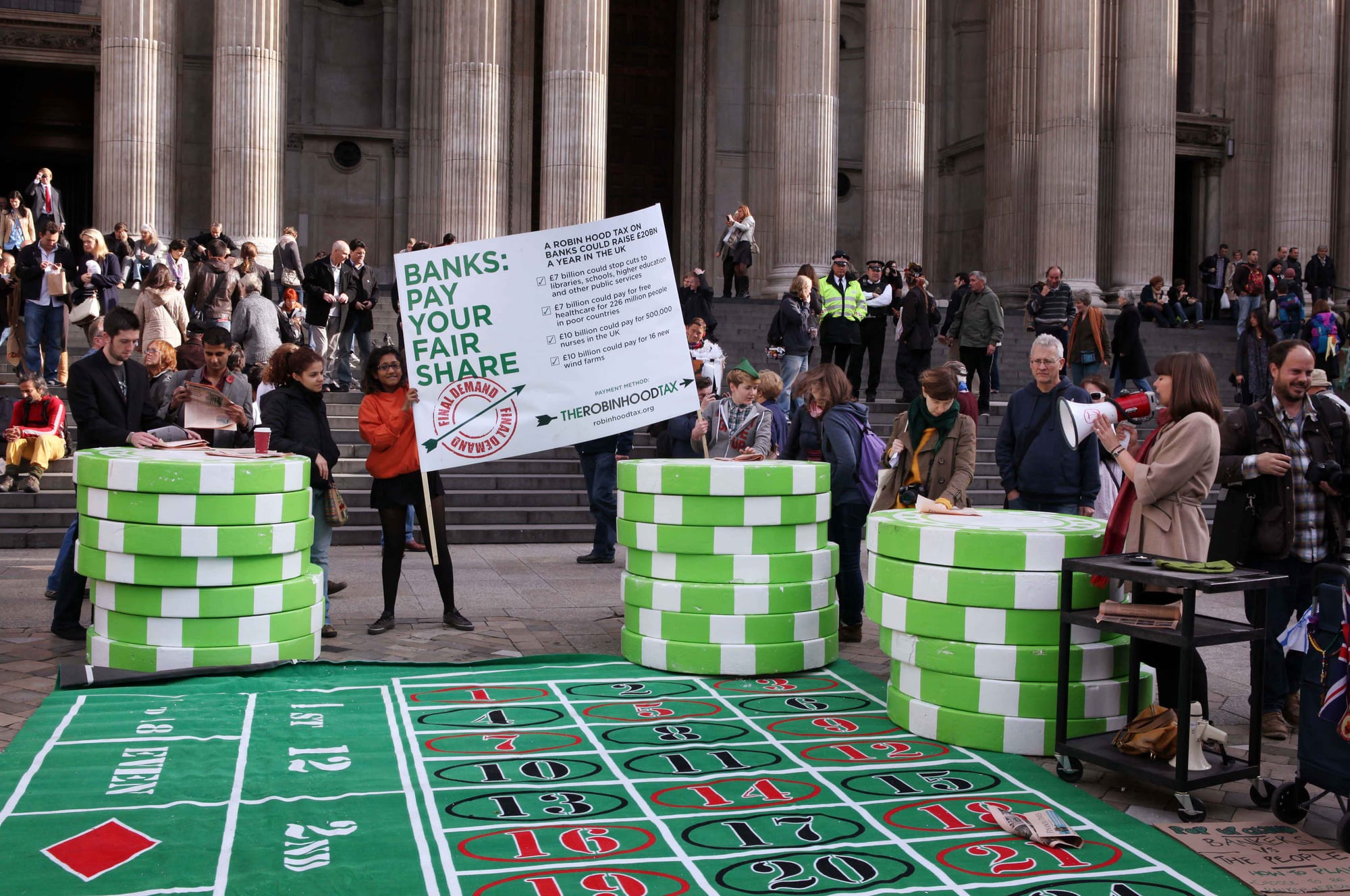 Organised by the Robin Hood Tax campaign, the banker's billionaire pop-up casino took place at the occupy camp outside St Paul's cathedral, London. Bankers placed bets against the public in a game they were guaranteed to win. Part of a coordinated day of action happening in 20 cities around the world ahead of the G20 summit next week. 
Credit: David Sandison, Robin Hood Tax Campaign
Read more>>

robinhoodtax.org.uk/latest/come-and-gamble-bankers-billion-p...