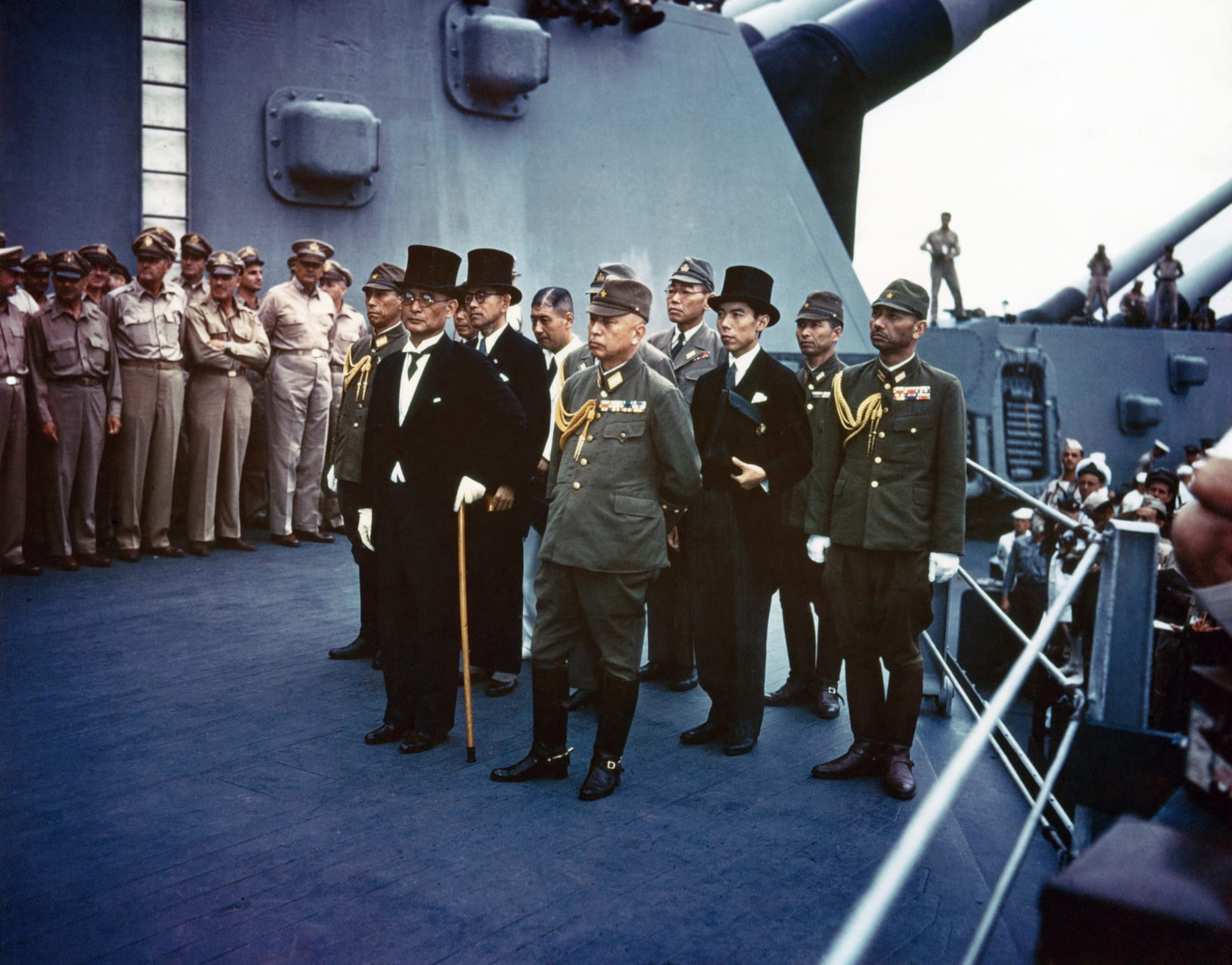 Surrender of Japan, Tokyo Bay, 2 September 1945: Representatives of the Empire of Japan on board USS Missouri (BB-63) during the surrender ceremonies.
Standing in front are:
Foreign Minister Mamoru Shigemitsu (wearing top hat) and General Yoshijirō Umezu, Chief of the Army General Staff.
Behind them are three representatives each of the Foreign Ministry,  the Army and the Navy. They include, in middle row, left to right:

Lieutenant General Shūichi Miyakazi, Army;
Katsuo Okazaki, Foreign Ministry;
Rear Admiral Tadatoshi Tomioka, Navy;
Toshikazu Kase, Foreign Ministry, and
Major General Yatsuji Nagai, Army.
In the back row, left to right (not all are visible):

Rear Admiral Ichirō Yokoyama, Navy;
Saburo Ōta, Foreign Ministry;
Katsuo Shiba, Navy, and
Kazushi Sugita, Army.
(Identities those in second and third rows are from an annotated photograph in Naval Historical Center files.)