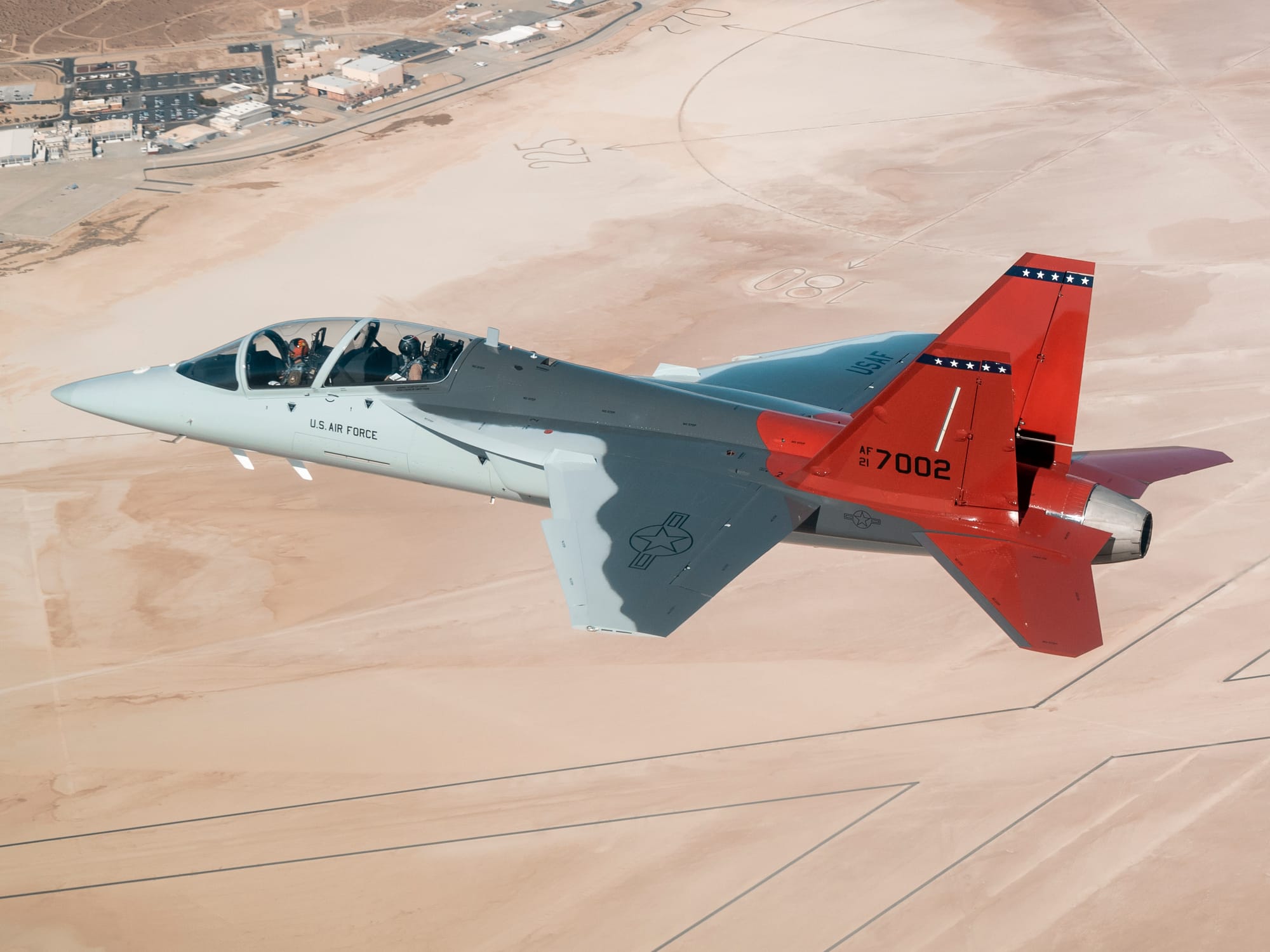 The first T-7A Red Hawk, piloted by USAF test pilot Maj. Jonathan“Gremlin” Aronoff and Boeing test pilot Steve “Bull” Schmidt, soars over Edwards Air Force Base, California, Nov. 8, prior to arrival. The T-7A will replace the 1960s-era T-38 aircraft by providing advanced pilot training capabilities for aviators learning to fly both tactical and bomber aircraft. (Air Force photo by Bryce Bennett)
