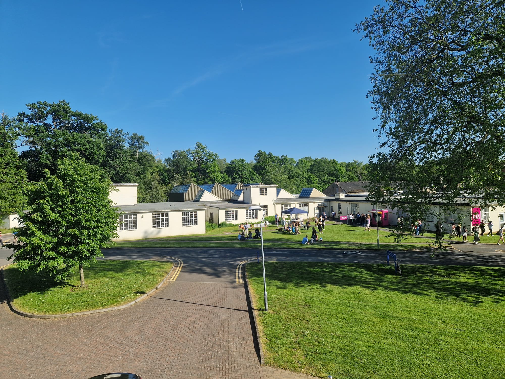 Temporary Office Building 1 (TOB1) on the Whitekights Park campus of the University of Reading. Originally built by the government during the second world war as part of a regional civil defence complex (that also included the mirror image TOB2 and an atom bomb proof bunker) this building was inherited by the university when it acquired Whiteknights Park, and was latterly used for the Department of Fine Art, and a few other ancillary functions. It proved far from temporary, and lasted until 2024, when it was demolished in order to be replaced by the new headquarters for the European Centre for Medium-Range Weather Forecasts. This photograph was taken during the last Fine Art graduation party before the department relocated.