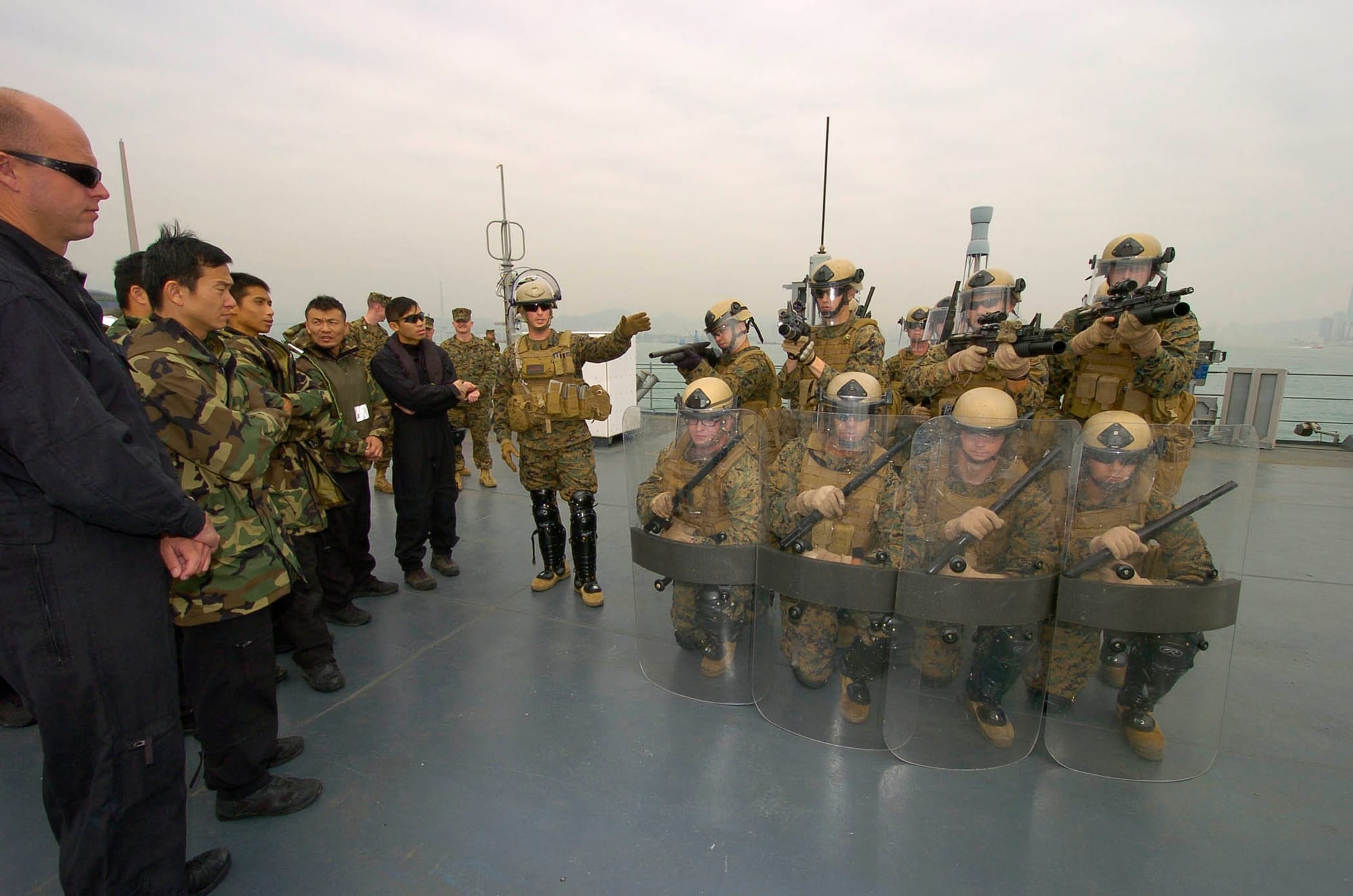 Sgt. David Zimmerman, center left, assigned to Fleet Anti-Terrorism Security Team Pacific, explains Marine Corps riot control techniques during a professional development exchange aboard the U.S. 7th Fleet command ship USS Blue Ridge with members of the Flying Tigers from the Hong Kong Police Department Special Duties Unit. Blue Ridge is conducting a spring patrol.