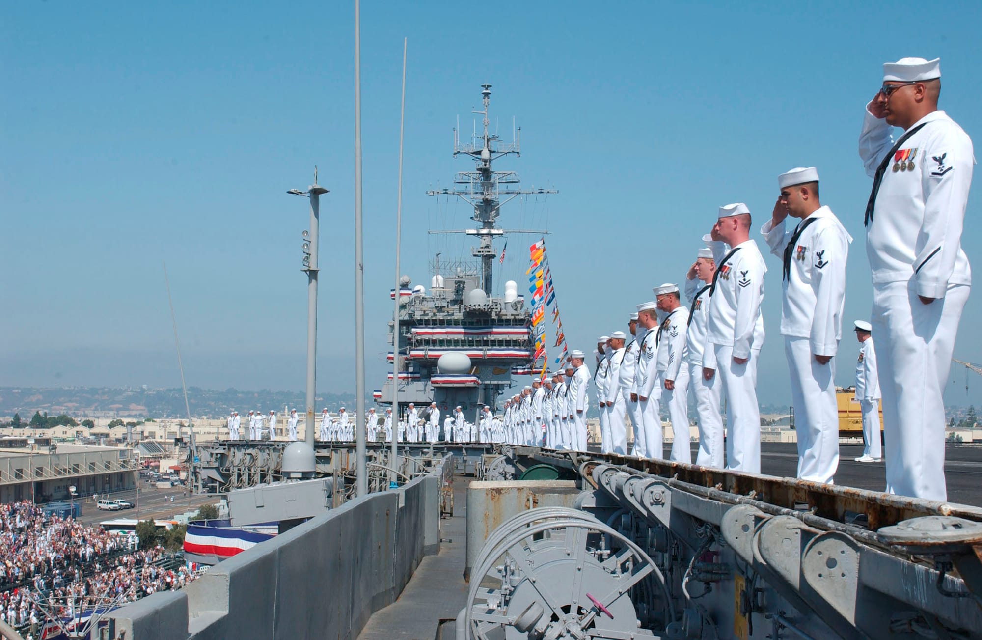 Naval Air Station North Island, Calif. (Aug. 7, 2003) -- Sailors aboard USS Constellation (CV 64) render honors with the playing of the National Anthem during the decommissioning ceremony for Constellation. The ceremony, held at Naval Air Station North Island, marked the end of the carrier's nearly 42 years of service to the nation. During Constellation’s commissioned service, she completed 21 deployments and most recently completed combat operations in support of Operation Iraqi Freedom. Constellation, decommissioned in San Diego at the Naval Air Station North Island, will be towed to Bremerton, Wash., where she will remain in Puget Sound Naval Shipyard. Constellation is the second oldest aircraft carrier in the Navy and one of only three remaining conventionally powered aircraft carriers in its arsenal.