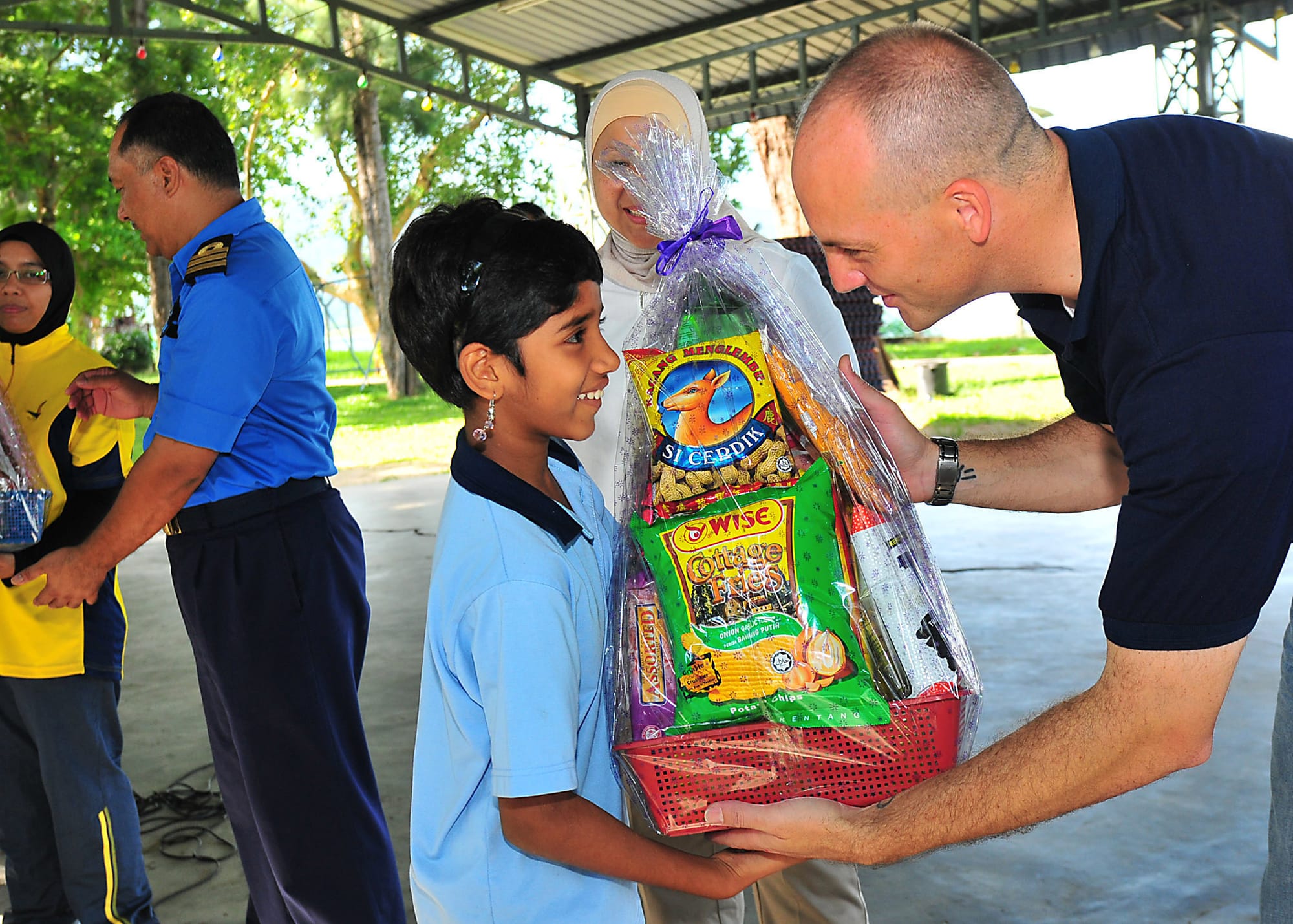 LUMUT, Malaysia (June 9, 2010) Lt. Mark Hughes, chaplain for Destroyer Squadron (DESRON) 31, presents a gift basket to a girl from the Rumah Wawasan Children's Home during a Cooperation Afloat Readiness and Training (CARAT) Malaysia 2010 community service project. CARAT 2010 is a series of bilateral exercises held annually in Southeast Asia to strengthen relationships and enhance force readiness. (U.S. Navy photo by Mass Communication Specialist 2nd Class David A. Brandenburg/Released)