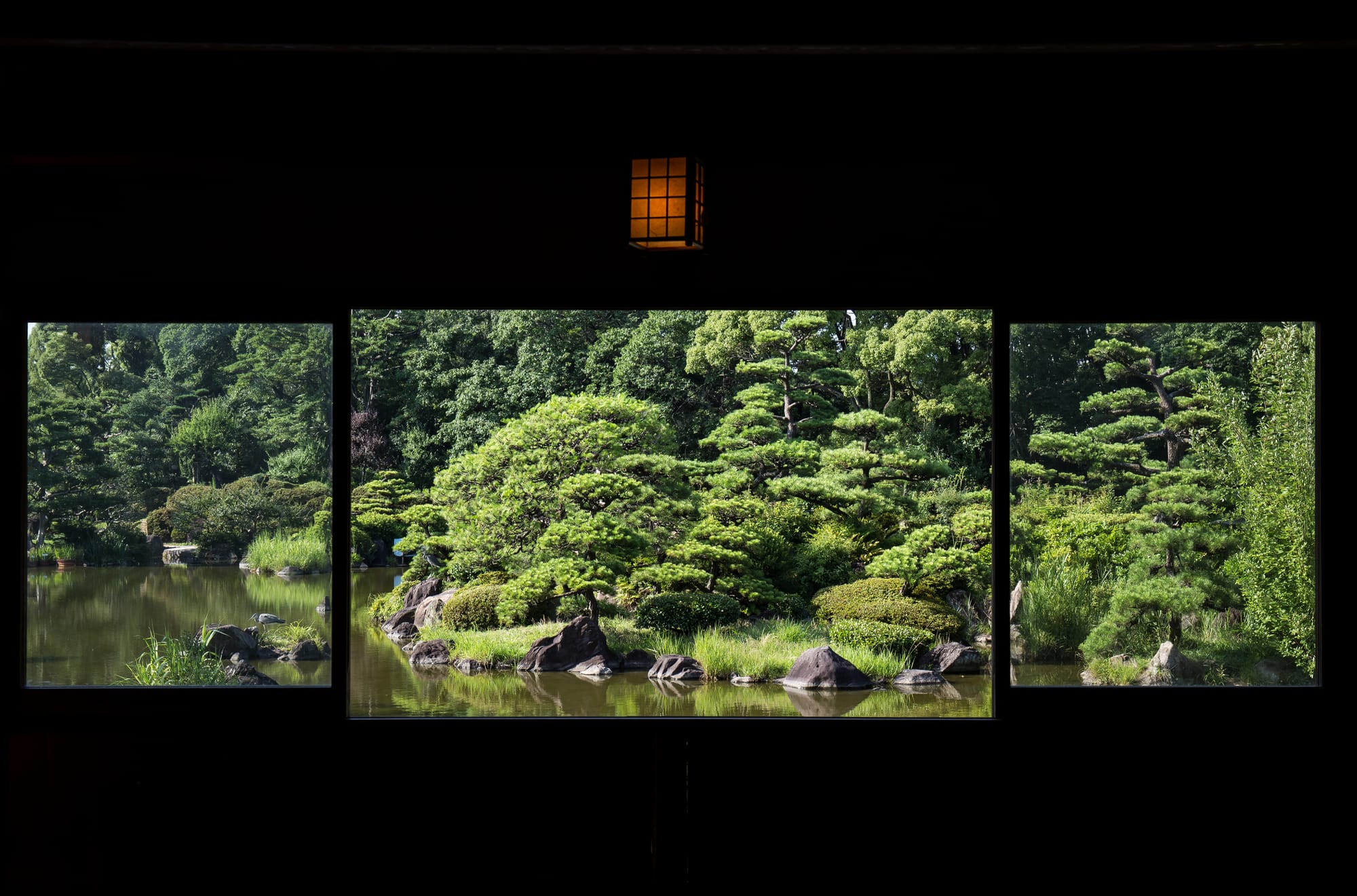 A Japanese garden scene through a window from the Keitaku-en chickee.