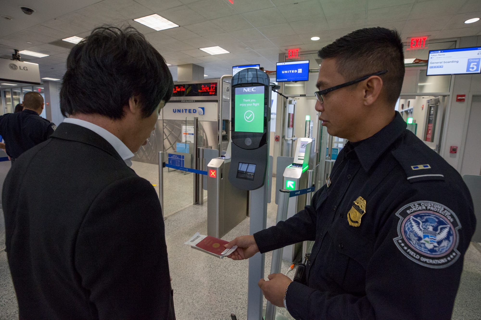 A U.S. Customs and Border Protection, Office of Field Operations, officer assists a passenger with the Biometric Facial Recognition process prior to boarding a flight at Houston International Airport on February 12, 2018. ..Photographer: Donna Burton