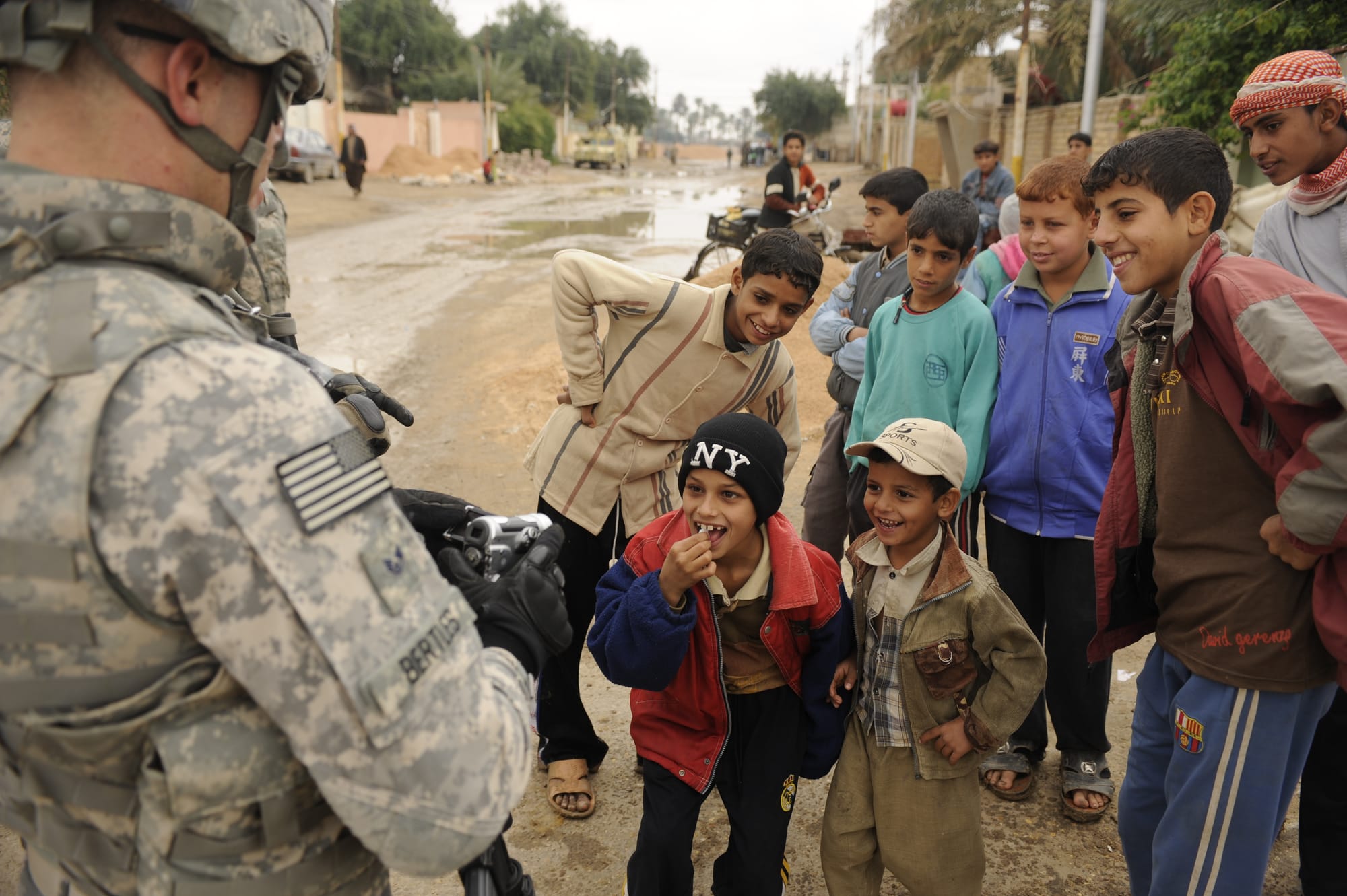 Iraqi children gather around U.S. Air Force Staff Sgt. David Bertles, assigned to the 1st Combat Camera Squadron, Charleston Air Force base, S.C., as he documents cordon and knock operations in Afak, Iraq, Nov. 30. The operation was led by U.S. Soldiers from the 2nd Battalion, 8th Infantry Regiment, 2nd Brigade Combat Team, 4th Infantry Division.