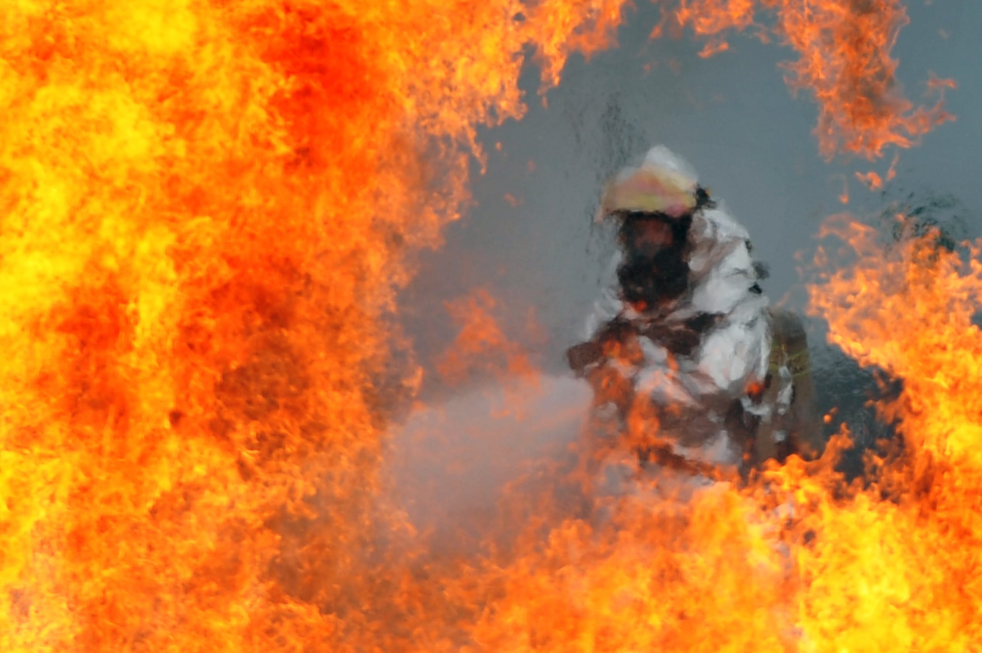 A U.S. Air Force firefighter sprays water at the fire of a simulated C-130 Hercules plane crash during operational readiness exercise Beverly Midnight 12-03 at Osan Air Base, Republic of Korea, on July 23, 2012. The exercise tests the ability of personnel to defend the base and conduct daily operations during a heightened state of readiness.