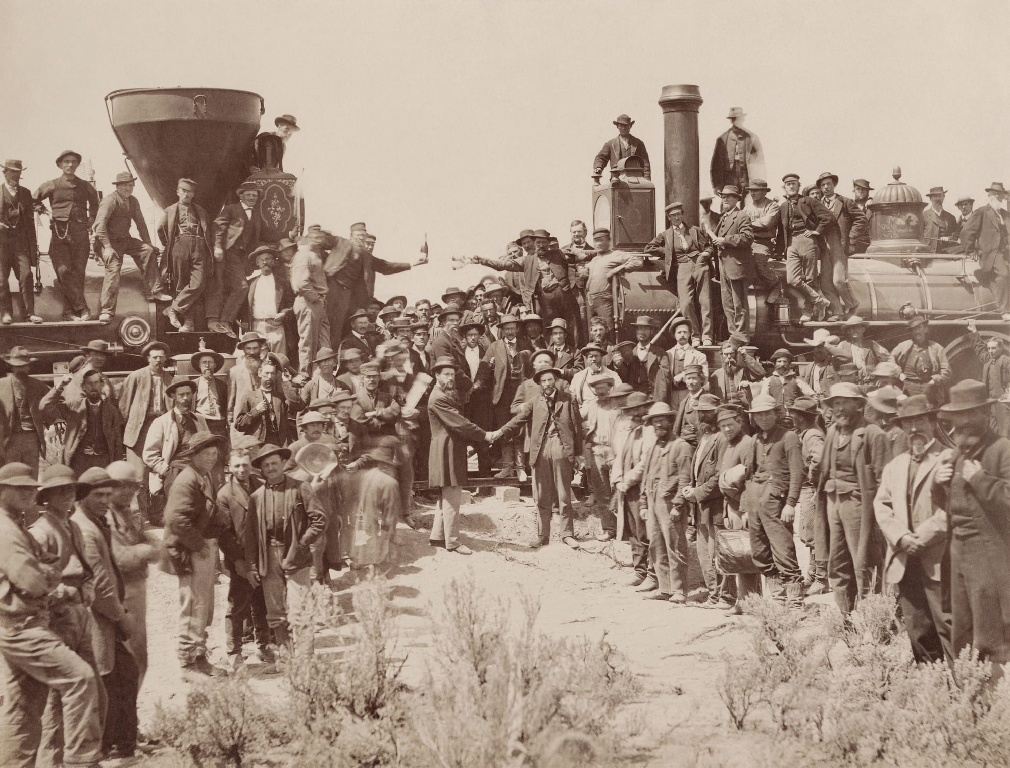 The ceremony for the driving of the golden spike at Promontory Summit, Utah on May 10, 1869; completion of the First Transcontinental Railroad. At center left, Samuel S. Montague, Central Pacific Railroad, shakes hands with Grenville M. Dodge, Union Pacific Railroad (center right).