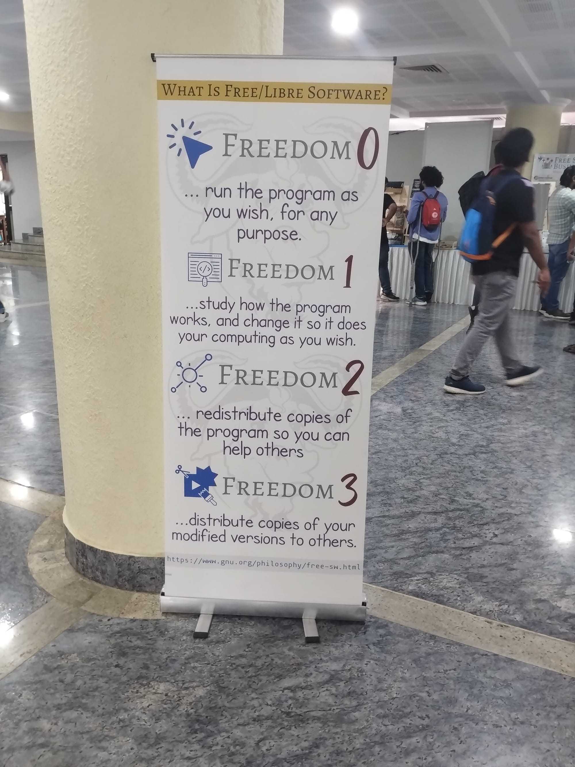 Large poster listing the four freedoms of free software at IndiaFOSS 2024