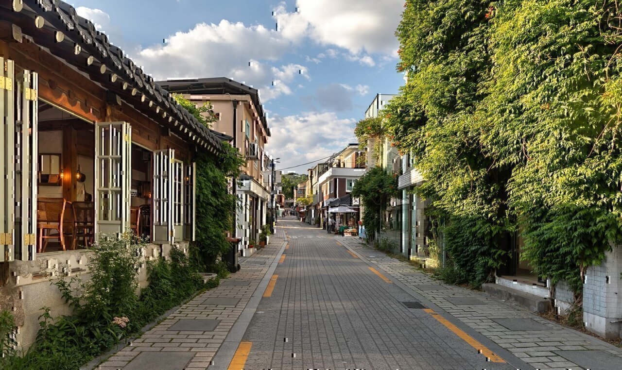 Gyedong-gil street with a building facade covered with climbing plants and a café with open windows, at golden hour, in Bukchon Hanok Village, Seoul, South Korea.