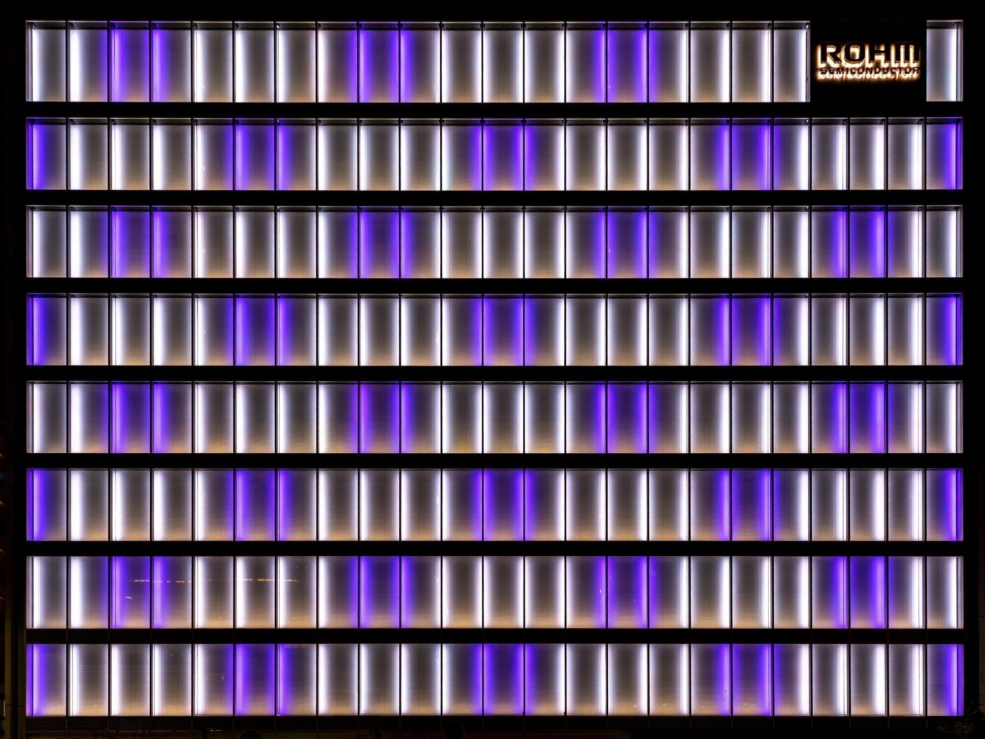 The illuminated white and purple facade of the office building of Rohm Semiconductor, a Japanese electronic parts manufacturer, in Shimogyo-ku, Kyoto, Japan.