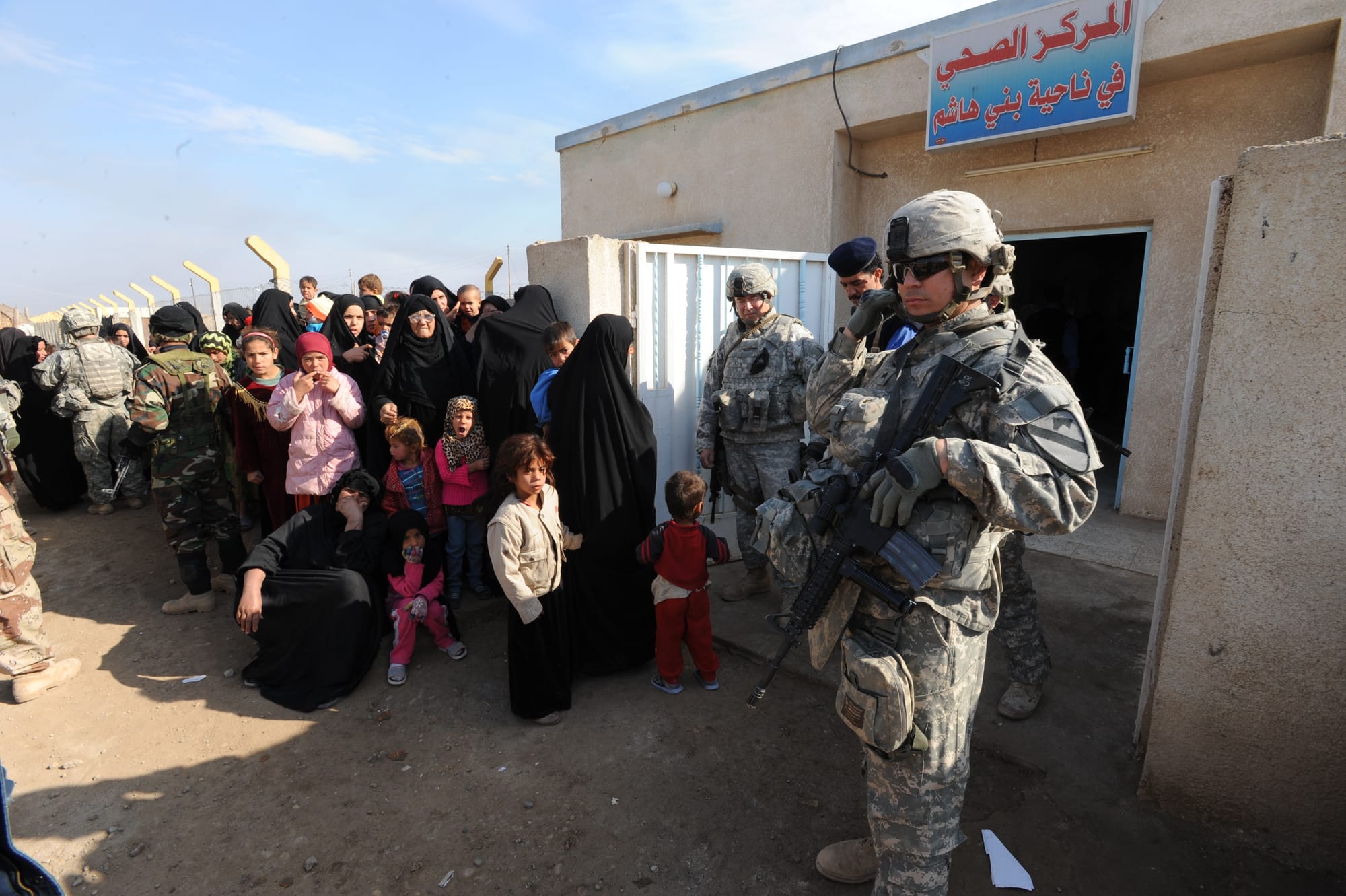 U.S. Army Cavalrymen of 1st Squadron, 9th Cavalry Regiment, 4th Brigade Combat Team, 1st Cavalry Division, keep order as Iraqi women and children from rural Maysan province, Iraq, gather for medical care at the clinic in Beni Hashim. First Squadron has organized this Civil Military Engagement to bring medical supplies and services to the area, Jan. 25, 2009.