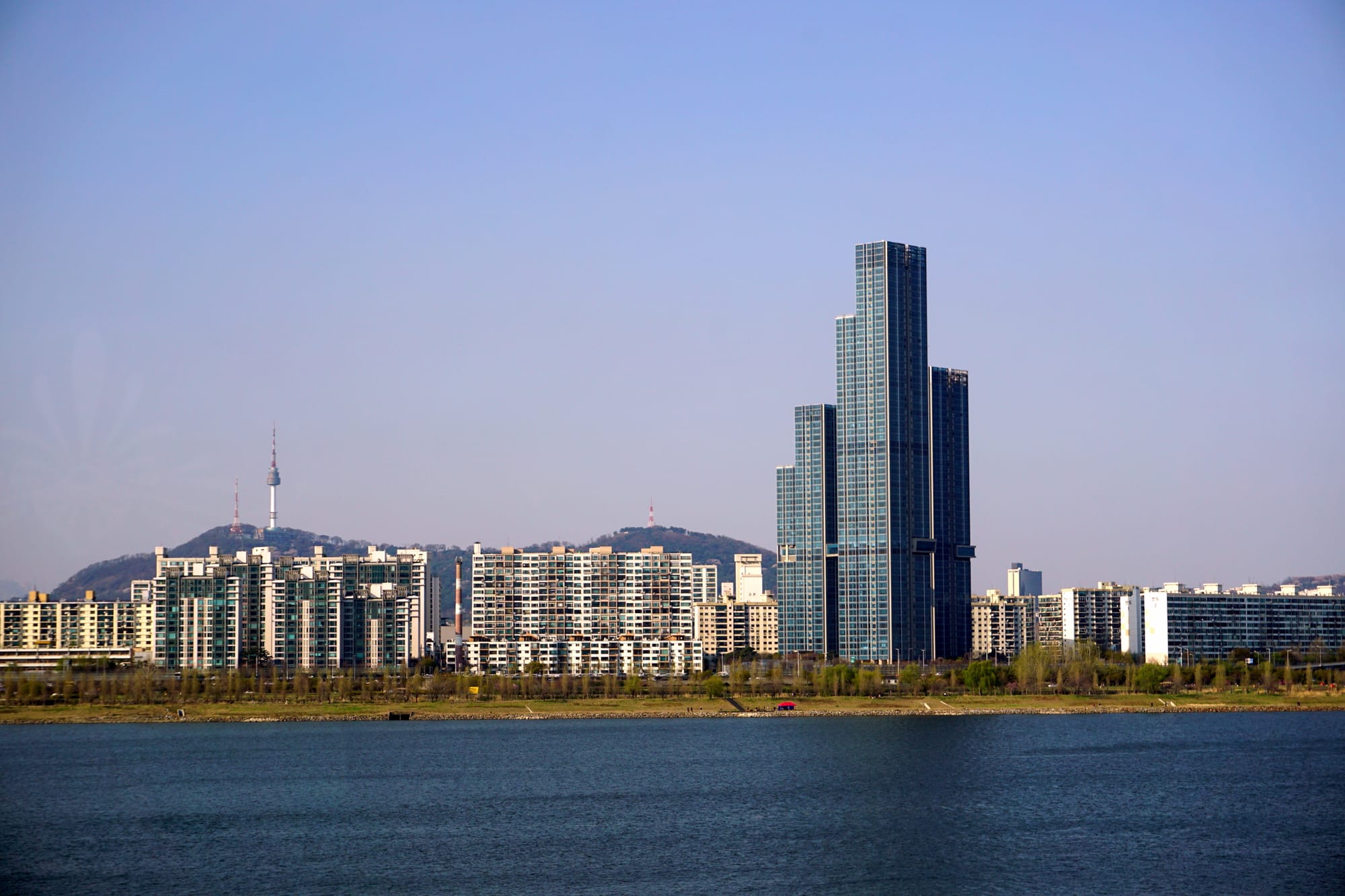 This photo shows the N Seoul Tower, which is currently the tallest observation tower in South Korea, and Raemian Caelitus, a high-rise apartment building, from the Han River.