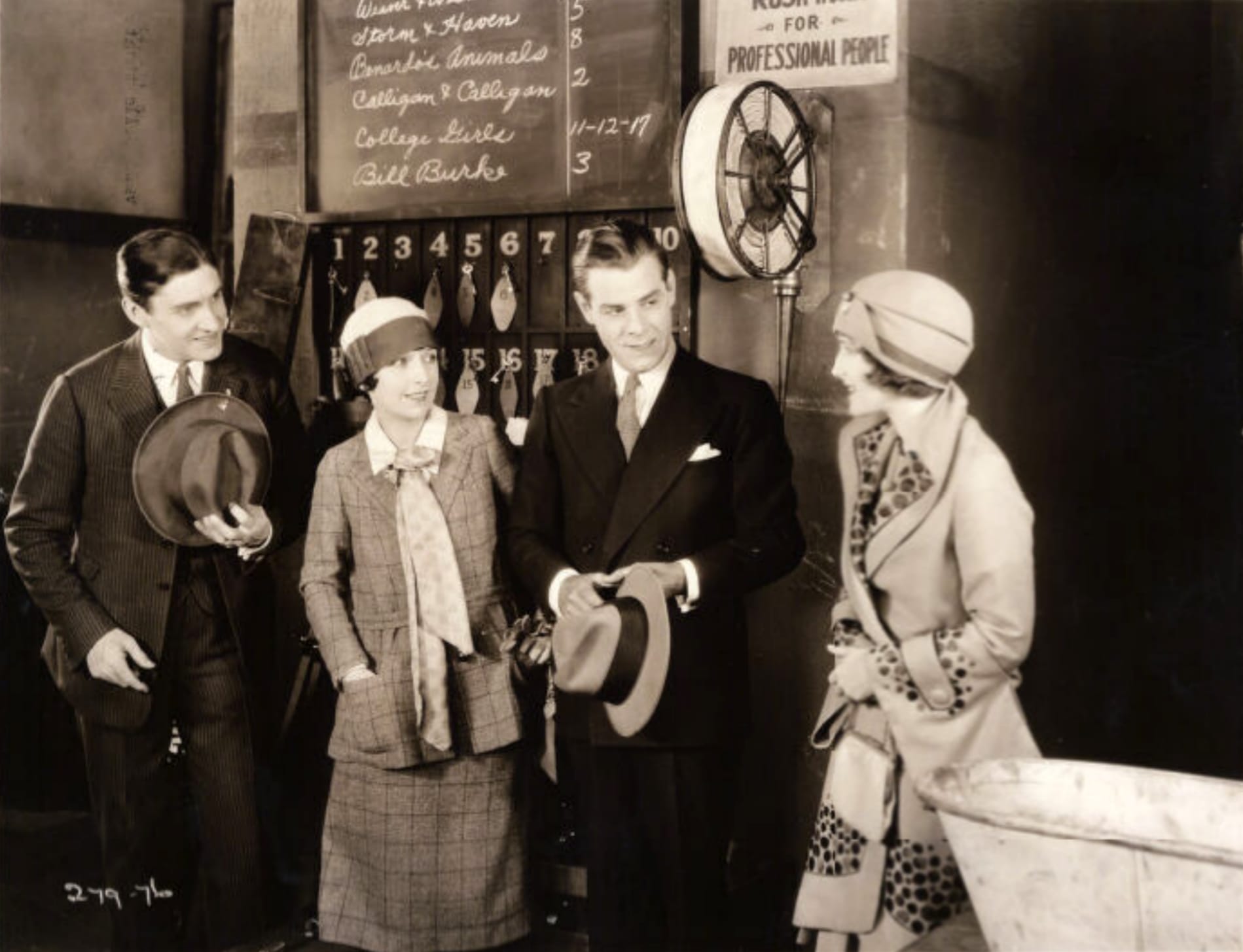 (From left) Oscar Shaw, Norma Shearer, Charles Meakin, and Dorothy Phillips in Upstage. Text from back of photograph: Oscar Shaw and Norma Shearer arrive "Backstage" in the vaudeville theatre in Metro-Goldwyn-Mayer's Upstage