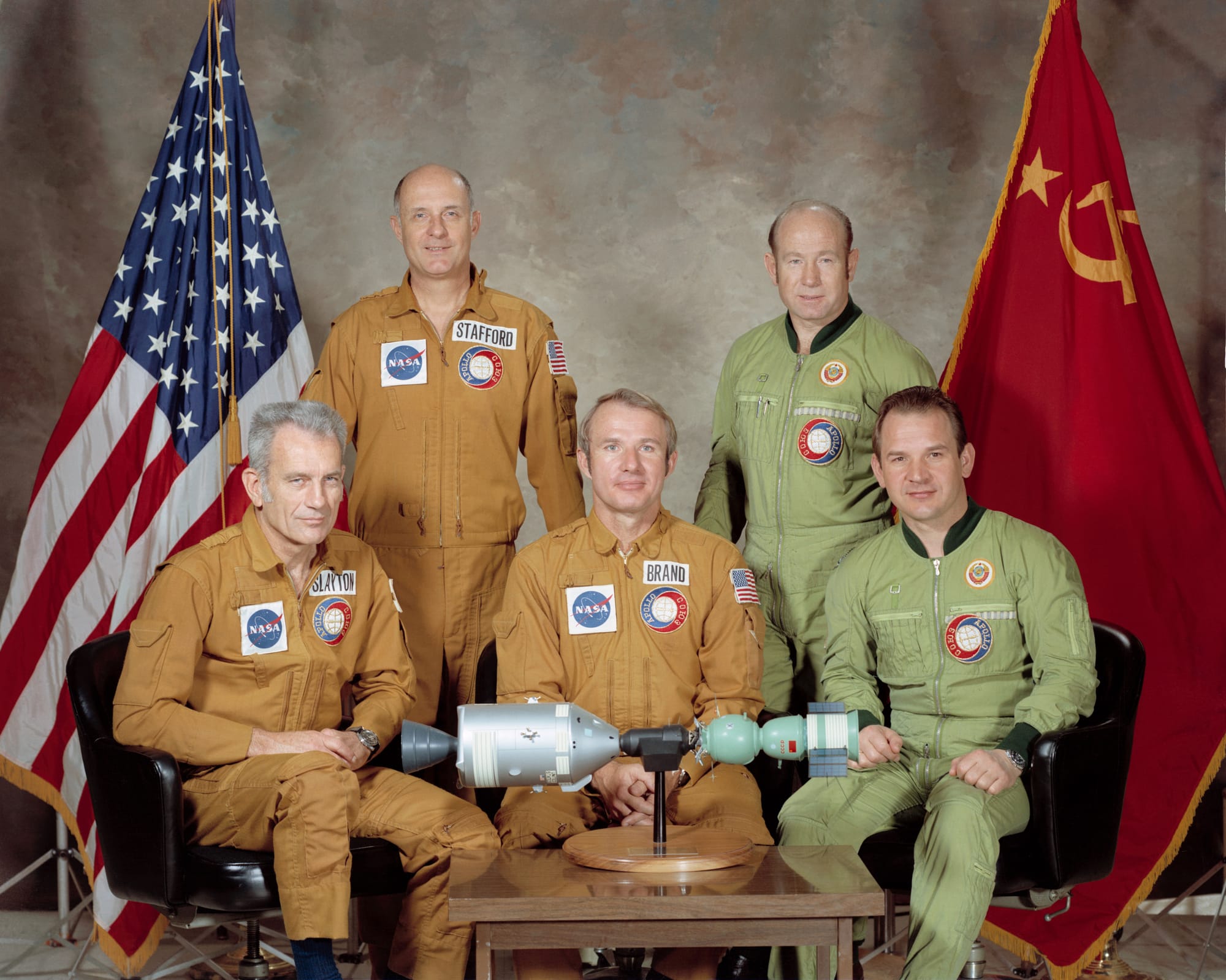 S75-22410 (March 1975) --- These five men compose the two prime crews of the first-ever two-nation cooperative space mission, known in the US as the Apollo-Soyuz Test Project (ASTP) and in the Soviet Union as the Soyuz-Apollo Experimental Flight (Russian: Экспериментальный полёт Союз-Аполлон, Eksperimantalniy polyot Soyuz-Apollon). This was a docking mission in Earth orbit scheduled for July 1975. They are astronaut Thomas P. Stafford (standing on left), commander of the American crew; cosmonaut Aleksey A. Leonov (standing on right), commander of the Soviet crew; astronaut Donald K. Slayton (seated on left), docking module pilot of the American crew; astronaut Vance D. Brand (seated center), command module pilot of the American crew; and cosmonaut Valeriy N. Kubasov (seated on right), engineer on the Soviet crew.
The crew members wear the same mission patch, but oriented to reflect "Soyuz-Apollo" or "Apollo-Soyuz", as the program was called in their respective countries.