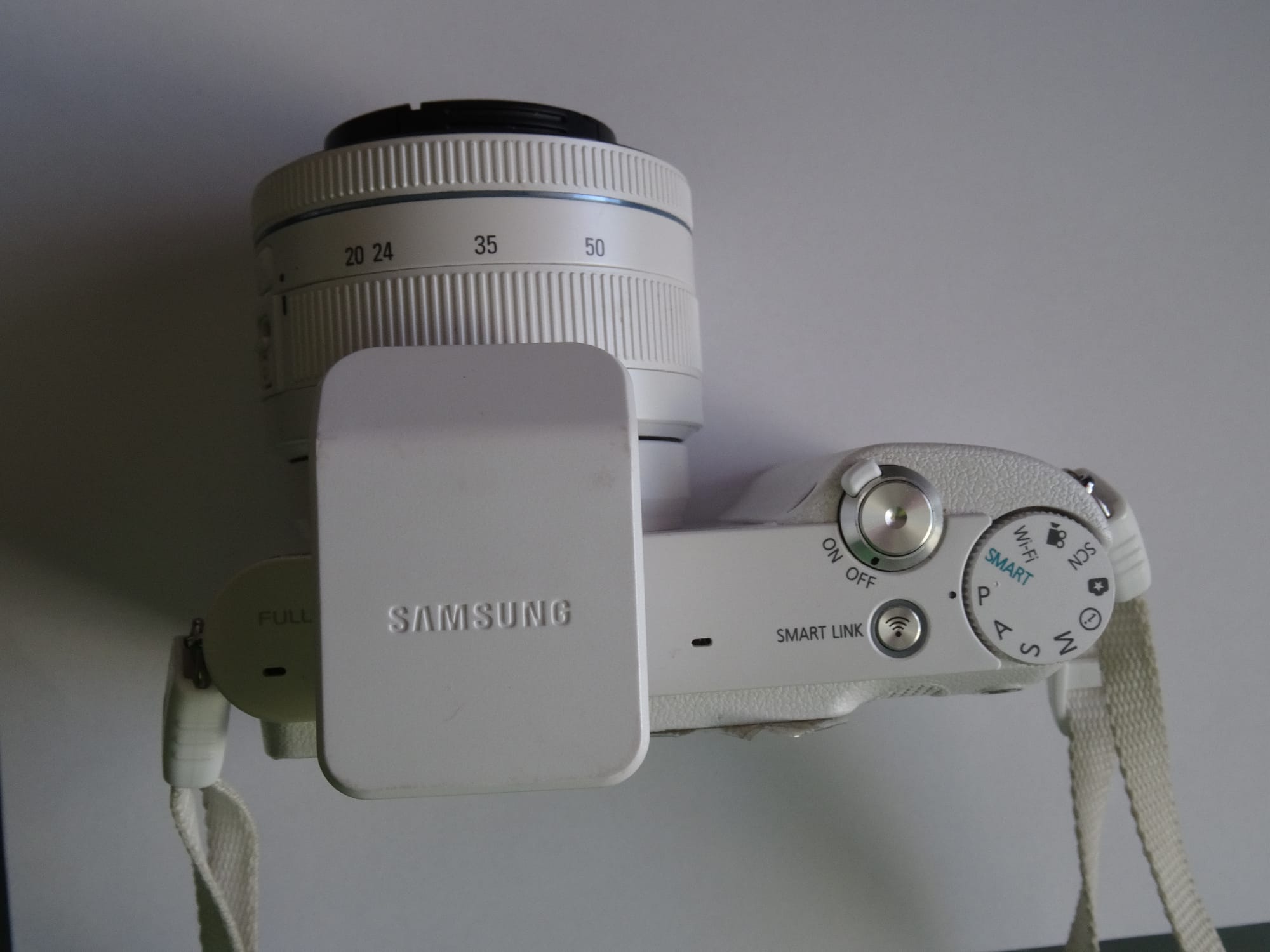 The Samsung NX1100 Digital Still Camera offers an ideal balance of size, customizability, and performance. Together with the included copy of Adobe Photoshop Lightroom 4, you'll be shooting, organizing, and post-processing photos like a pro. A sharp, 20.3-megapixel APS-C CMOS sensor, a bundled 20-50mm lens, and an included external flash unit means you'll be taking great photos no matter where you are. The camera has the Samsung NX mount, so you can choose from 12 different Samsung NX lenses. And with built-in Wi-Fi, you can share your best shots right away without fussing with cables and card readers.
Includes Adobe Photoshop Lightroom 4 Software
Bundled 20-50mm Lens
The NX1100 is bundled with a 20-50mm lens, which provides ideal range for all-around use. The camera uses the Samsung NX mount so you can choose among an assortment of lenses for your needs.
Flash Unit Included
The SEF-8A flash unit included with the camera connects to the camera's hot shoe mount. This flash strobe has a guide number of 8 meters at ISO 100. Its compact dimensions make it easy to carry around with you, and it folds down against the top of the lens to stay out of the way when not in use.
Compose on a Brilliant 3-Inch Display
On the back of the camera is a brilliant 3-inch display that lets you compose and review your photos comfortably and accurately. The bright display has a VGA (640x480) resolution with 921k dots, so you'll be able to see all the details.
Full HD Video Recording
The NX1100 has 1,080p Full HD movie recording capabilities. The CMOS sensor gives you precise autofocus even as you're recording, 

   Camera Type Smart Compact System Camera
   Effective Pixel&nbsp;? Approx. 20.3 Mega-pixels
   Image Sensor Type CMOS
   Type 20-50mm F/3.5-5.6 ED Lens (White) EX-S2050BNW/US
   Main LCD Screen 3" TFT LCD
   Optical Image Stabilization OIS Mode1 / Mode2 / OFF

Full Specifications
Design

   Color&nbsp;? White
   Camera Type Smart Compact System Camera

In The Box

   Included NX1100 20.3 SMART Camera (White)
   20-50mm F/3.5-5.6 ED Lens (White)
   SEF-8A Hot Shoe Mount Flash Unit
   BP1030 Lithium-ion Battery
   BC1030 Battery Charger & AC Cable
   Body Cap
   Camera Strap
   Micro USB Cable

Image sensor

   Effective Pixel&nbsp;? Approx. 20.3 Mega-pixels
   Total Pixel&nbsp;? Approx. 21.6 Mega-pixels
   Image Sensor Type CMOS

Lens

   Type 20-50mm F/3.5-5.6 ED Lens (White) EX-S2050BNW/US
   Mount Samsung NX Mount
   Included Lens EX-S2050BNW/US

Shutter Speed

   Range
   Modes Auto：1/4000sec. ~ 30sec.
   Manual：1/4000sec. ~ 30sec. (1/3EV step)
   Bulb ( Limit time&nbsp;: 4min. )

Exposure

   ISO Equivalent&nbsp;? Auto, 100, 200, 400, 800, 1600, 3200, 6400, 12800 (1 or 1/3EV step)
   * AUTO ISO Upper Level is Selectable. (Up to ISO3200)
   Metering System&nbsp;? TTL 221(17x13) Block Segment
   Metering&nbsp;: Multi, Center-weighted, Spot
   Metering Range&nbsp;: EV 0-18 (ISO 100 · 30mm, F2)

Focusing

   Modes Single AF, Continuous AF, MF

Shooting

   Modes SmartAuto(2.0), Program, Aperture Priority, Shutter Priority, Manual, Lens Priority, Magic, cene, Movie, Wi-Fi
   RAW format shooting SRW

Display

   Field of View&nbsp;? Approx. 100%
   Main LCD Screen 3" TFT LCD
   Resolution 8VGA ( 640X40 ) 921k dots

Video

   Movie Clip With Audio or without Audio (User Selectable, Recording Time&nbsp;: 25 minutes)

Flash

   Modes Smart Flash, Auto, Auto+Red-eye reduction, Fill-in, Fill-in+Red-eye reduction, 1st Curtain, 2nd Curtain, OFF
   Sync. Speed Less than 1/180 sec.
   Range 28mm Wide-angle (Equivalent to 35mm)
   Accessory Samsung External Flash Available (SEF-42A, SEF220A&nbsp;: Optional)

Image Stabilization

   Optical Image Stabilization OIS Mode1 / Mode2 / OFF

Smart Settings

   Smart Auto 2.0
   Smart Filter (Movie) Vignetting, Miniature, Fish-Eye, Sketch, De-fog, Halftone Dots, Soft Focus,Old Film1, Old Film2, Negative
   Smart Filter (Still Image) Miniature, Soft Focus, Old Film1, Old Film2,, Halftone Dots, Sketch, Fish-Eye, De-fog Negative

Picture Effects

   Picture Wizard Modes:
   Standard, Vivid, Portrait, Landscape, Forest, Retro, Cool, Calm, Classic, Custom (1~3)
   Parameters:
   Contrast, Sharpness, Saturation, Color

i-Function

   i-Effect i-Scene (depends on Lens)
   Smart Filter (Vignetting, Minature, Fish-Eye, Sketch, Defog, Halftone Dot)
   i-Zoom x1.2, 1.4, 1.7, 2.0

Dust Reduction

   Dust Reduction Type: Supersonic drive

White Balance

   Modes Auto, Daylight, Cloudy, Fluorescent (W, N, D), Tungsten, Flash, Custom, K(Manual)

Storage

   File Format&nbsp;? RAW (SRW), JPEG (EXIF 2.21), DCF, DPOF 1.1, PictBridge 1.0
   Image Size 20.0M RAW 53
   20.0M (3:2)&nbsp;: Super Fine 186, Fine 364, Normal 535
   10.1M (3:2)&nbsp;: Super Fine 378, Fine 724, Normal 1043
   5.9M (3:2)&nbsp;: Super Fine 626, Fine 1168, Normal 1642
   2.0M (3:2)&nbsp;: Super Fine 1627, Fine 2742, Normal 3553
   Burst (5.0M)&nbsp;: Super Fine 731, Fine 1349, Normal 1878
   7.8M (16:9)&nbsp;: Super Fine 485, Fine 919, Normal 1310
   4.9M (16:9)&nbsp;: Super Fine 747, Fine 1376, Normal 1912
   2.1M (16:9)&nbsp;: Super Fine 1573, Fine 2666, Normal 3468
   13.3M (1:1)&nbsp;: Super Fine 289, Fine 560, Normal 814
   7.0M (1:1)&nbsp;: Super Fine 536, Fine 1010, Normal 1432
   4.0M (1:1)&nbsp;: Super Fine 893, Fine 1621, Normal 2224
   1.1M (1:1)&nbsp;: Super Fine 2645, Fine 4057, Normal 4936

Wireless Connectivity

   Wi-Fi Yes (IEEE 802.11n support)

Inputs & Outputs

   USB 2.0 USB 2.0 (HI-SPEED)
   Video Out NTSC, PAL (user selectable)
   HDMI 1.4a&nbsp;: (1080i, 720P, 576P / 480P)

Dimensions

   Product Size (WxHxD) 4.59" x 2.46" x 1.44"

Weight

   Product without battery and card 0.48 lb.

Power

   Power Source Rechargeable Battery
   Battery BP1030 (1030mAh)

System Requirements

   Windows PC with processor better than Intel Pentium III 500MHz
   (Intel Pentium 800MHz or higher recommended)
   Windows XP / Vista / 7
   Minimum 256MB RAM (512MB or more recommended)
   250MB of available hard disk space (1GB or more recommended)
   USB port,CD-ROM drive
   1024x768 pixels, 16-bit color display compatible monitor (24-bit color display recommended)
   Microsoft Direct X 9.0c or later
   intelli-studio 3.0
   Windows XP SP2 / Vista / 7
   Intel Core 2 Duo 1.66 GHz or higher / AMD AthlonTM X2 Dual-Core 2.2 GHz or higher
   Minimum 512MB RAM (1GB or more recommended)
   250MB of available hard disk space (1GB or more recommended)
   1024x768 pixels, 16-bit color display compatible monitor
   (1280x1024 pixcels, 32-bit color display recommended)
   USB 2.0, Microsoft DirectX 9.0c or later
   nVIDIA Geforce 7600GT or higher / ATI X1600 series or higher
   # 64-bit editions of Windows XP / Vista / and 7 are not supported
   Samsung RAW converter 4
   Windows XP / Vista / 7
   Intel Pentium, AMD Athlon Processor
   (Intel Pentium 4, AMD Athlon XP or later recommended)
   1GB or more RAM recommended
   Minimum 100MB of available hard disk space
   1024x768 pixels, Full Color (24-bit or higher) color display compatible monitor
   Macintosh Power Mac G3 or later
   Mac OS 10.4 or later 
   Minimum 256MB RAM (512MB or more recommended)
   Minimum 110MB of available hard-disk space
   USB port,CD-ROM drive
   Samsung RAW converter 4
   Mac OS X v10.6 / v10.5 / v10.4
   Power PC / Intel Processor-based or compatible computer (Core 2 Quad or later recommended)
   1GB or more RAM recommended
   Minimum 100MB of available hard disk space
   1024x768 pixels, 24-bit color display compatible monitor

Operating Conditions

   Humidity&nbsp;? 5 ~ 85%
   Temperature&nbsp;? 0 ~ 40 °C

Software

    Included in Box Adobe Lightroom Software CD