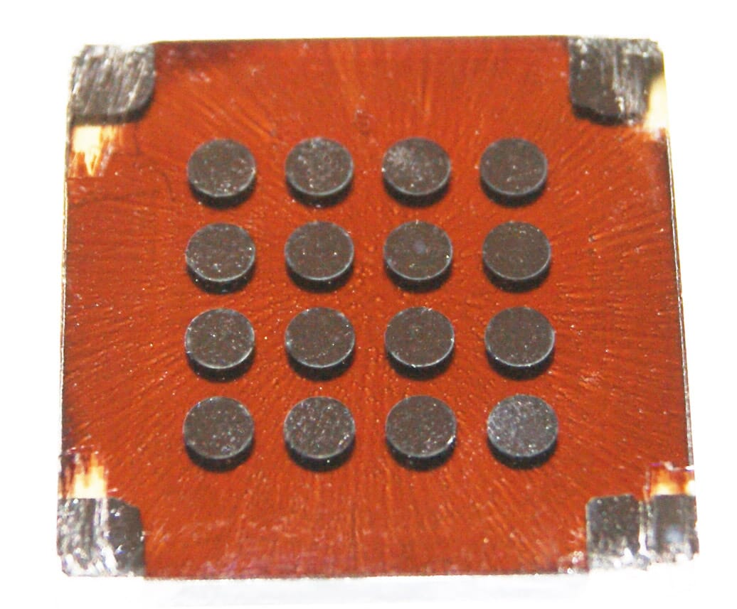 This experimental solar cell uses eight layers of colloidally-deposited quantum dots to efficiently capture a wide range of the solar spectrum. The metal dots on the front surfaces are the electrodes connected to each layer, two each for a total of sixteen. The "starburst" patterning of the cell material is due to the spin-casting technique.