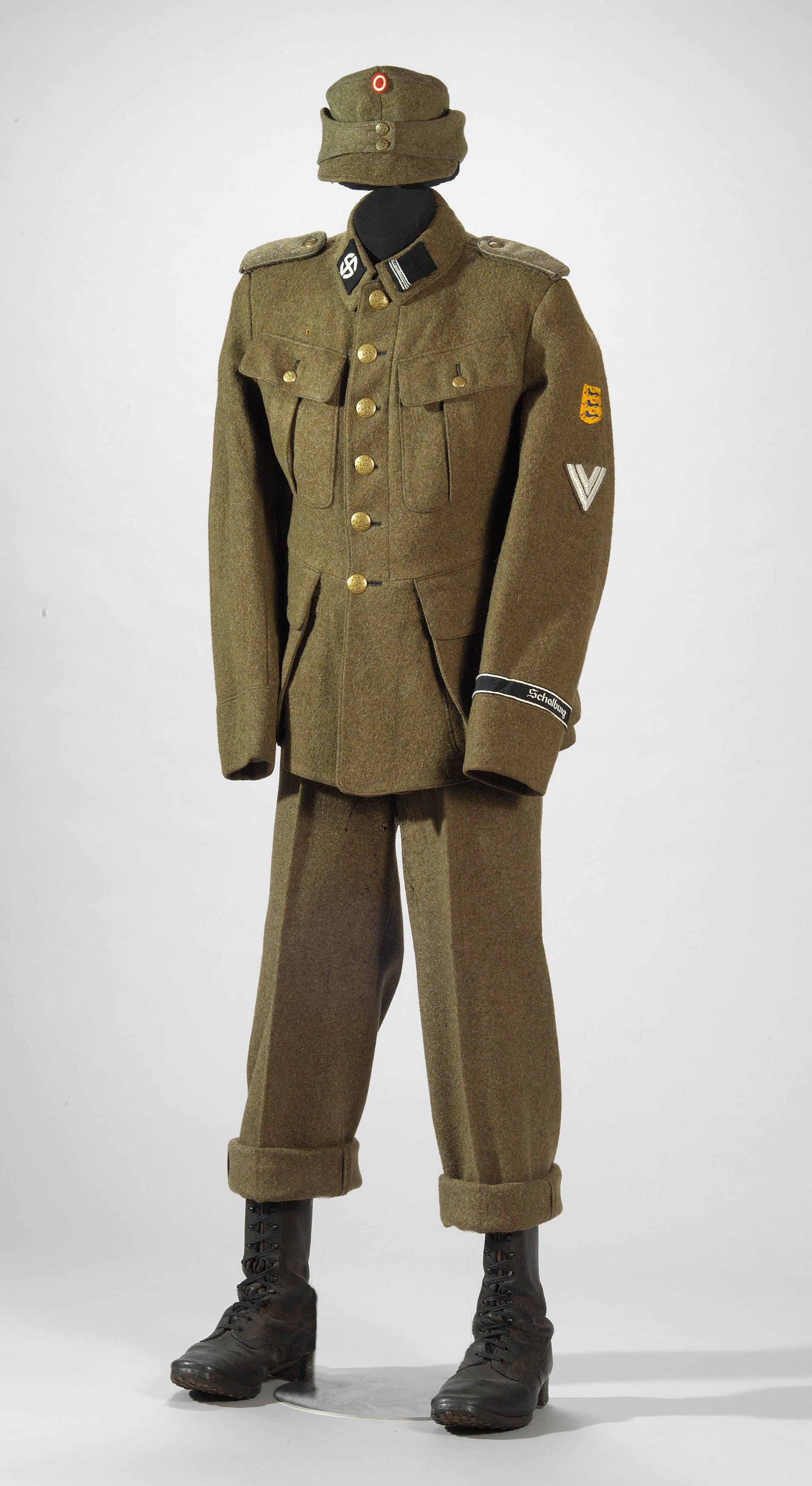 Field uniform for the Schalburg Corps (Danish: Schalburgkorpset, Germansk Korps), a Germanic volunteer corps 1943-45 and military unit within the Waffen-SS, the combat branch of the paramilitary SS organisation of Nazi Germany during World War II. Ordinary people recognized corps members by their presence in the city wearing their black SS uniforms. However, for military training, Danish army uniforms of the 1923 model were used.
Field cap with Danish cockade
Danish military field uniform coat/tunic model 1923, as part of the uniform for a Rottenführer in the Schalburg Corps
Yellow-brown fabric
Black collar patches, the right one with a sun symbol (round swastika, sun cross or sun wheel) as a divisional emblem, the left one with four horizontal silver stripes as Waffen-SS rank insignia|
Shoulder straps edged with silver braid on three sides
On the left upper sleeve, a yellow cloth badge with a (Danish national lesser coat of arms| (lille rigsvåben, nationalvåben) patch (national shield)
On the left arm a Rottenführer sleeve chevron;  vertical triangular shaped badge consisting of two 'V' shaped grey stripes embroidered on to a cloth base.
On the left sleeve cuff, a black cuff title (armband) with white edging stripes and "Schalburg" embroidered in white Fraktur script letters.
etc.
See Foreign Legions Of The Third Reich Vol. 1 by David Littlejohn (1987), pages 71–113, for detailed descriptions of uniforms and insignia of the pro-Nazi organizations and collaborationist military units in German-occupied Denmark during the Second World War.
The Germanic Corps, also known as Germansk Korps and renamed SS-Schalburgkorps, was formed under Germanic SS (German: Germanische SS) in April 1943 in Denmark under K.B. Martinsen's leadership. It had two groups: one was a paramilitary force, and the other included civilian sympathizers who provided funding. By winter 1943, it consisted of around 1,000 men led by Danish Waffen-SS officers. The SS-Schalburgkorps was deployed to suppress Danish resistance under the direction of Himmler, Best, and Martinsen.