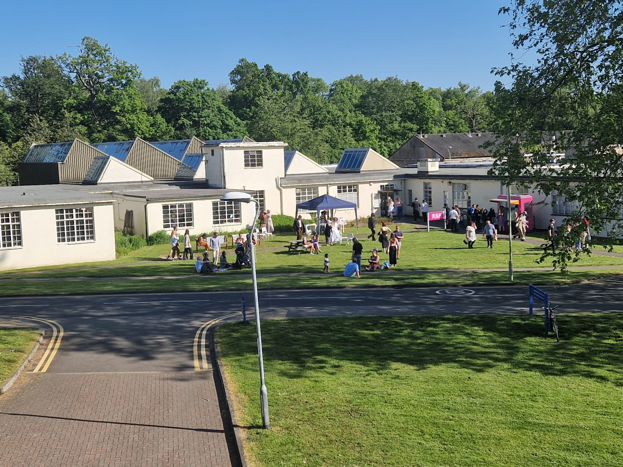 Temporary Office Building 1 (TOB1) on the Whitekights Park campus of the University of Reading. Originally built by the government during the second world war as part of a regional civil defence complex (that also included the mirror image TOB2 and an atom bomb proof bunker) this building was inherited by the university when it acquired Whiteknights Park, and was latterly used for the Department of Fine Art, and a few other ancillary functions. It proved far from temporary, and lasted until 2024, when it was demolished in order to be replaced by the new headquarters for the European Centre for Medium-Range Weather Forecasts. This photograph was taken during the last Fine Art graduation party before the department relocated.