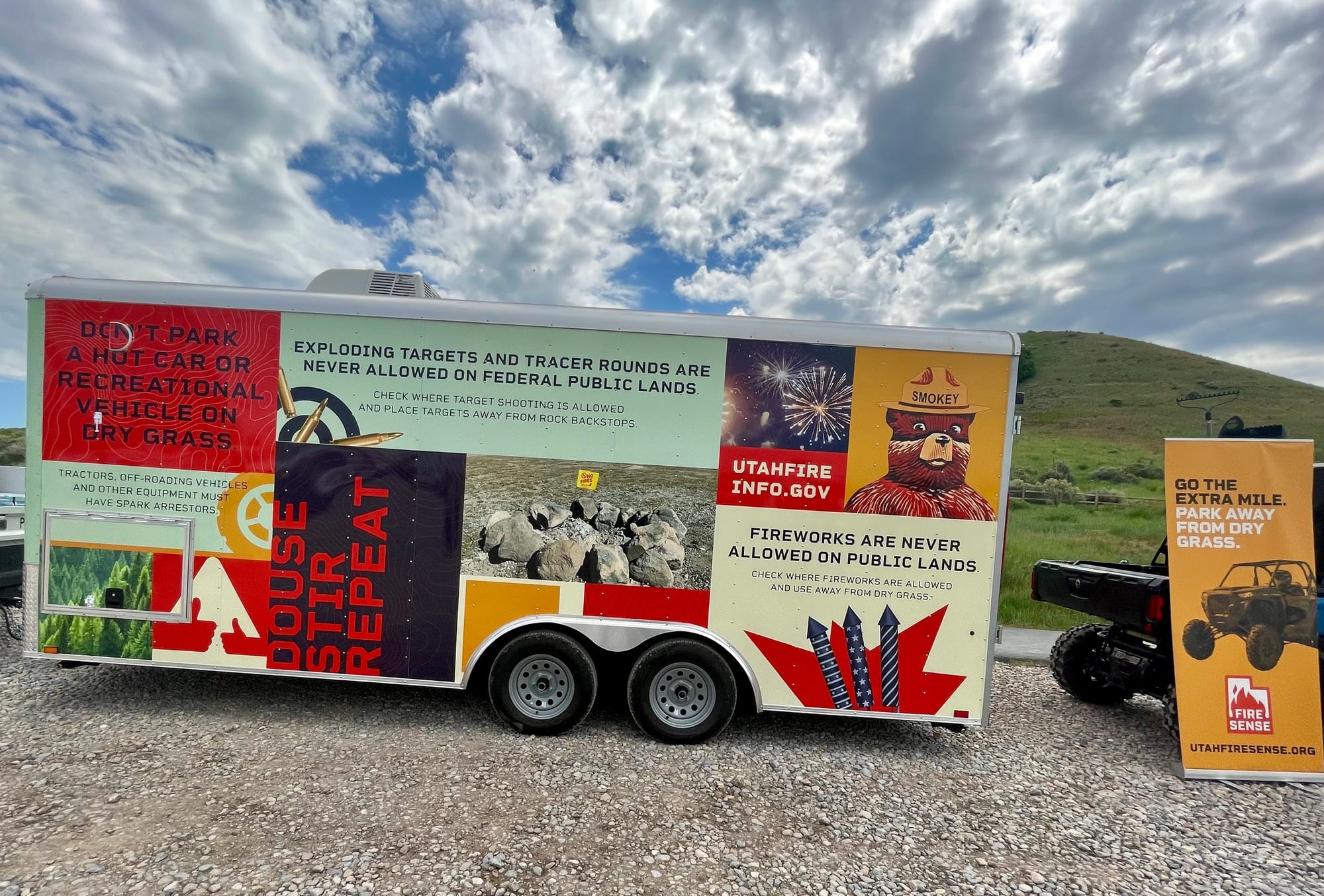 A trailer with wildfire prevention messaging on the side of it and grassy mountains in the background. The interagency media event for the Fire Sense campaign was held on June 5, 2023, to highlight the wildfire prevention campaign. Although we received record levels of moisture this winter, we still need to be vigilant as we enjoy all that Utah has to offer this summer. Governor Spencer Cox, along with State and federal officials, encouraged Utahns to continue using their Fire Sense this year. Learn more: utahfireinfo.gov. 
Photo by Javonne Goodman, BLM Utah