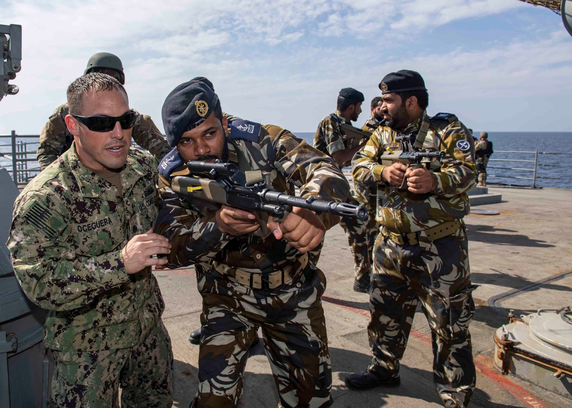 GULF OF OMAN (Nov. 8, 2019) U.S. Coast Guard Maritime Enforcement Specialist 1st Class Jeff Oceguera, left, assigned to U.S. Coast Guard Patrol Forces Southwest Asia, gives tactical team movement training to Royal Navy of Oman sailors as part of a visit, board, search, and seizure drill aboard the guided-missile cruiser USS Normandy (CG 60) during International Maritime Exercise 2019 (IMX 19). The exercise is a multinational engagement involving partners and allies from around the world designed to facilitate the sharing of knowledge and experiences across the full spectrum of defensive maritime operations. IMX 19 serves to demonstrate the global resolve in maintaining regional security and stability, freedom of navigation and the free flow of commerce from the Suez Canal south to the Bab el-Mandeb Strait through the Strait of Hormuz to the Northern Arabian Gulf. (U.S. Navy photo by Mass Communication Specialist 2nd Class Michael H. Lehman/Released) 191108-N-PC620-0547