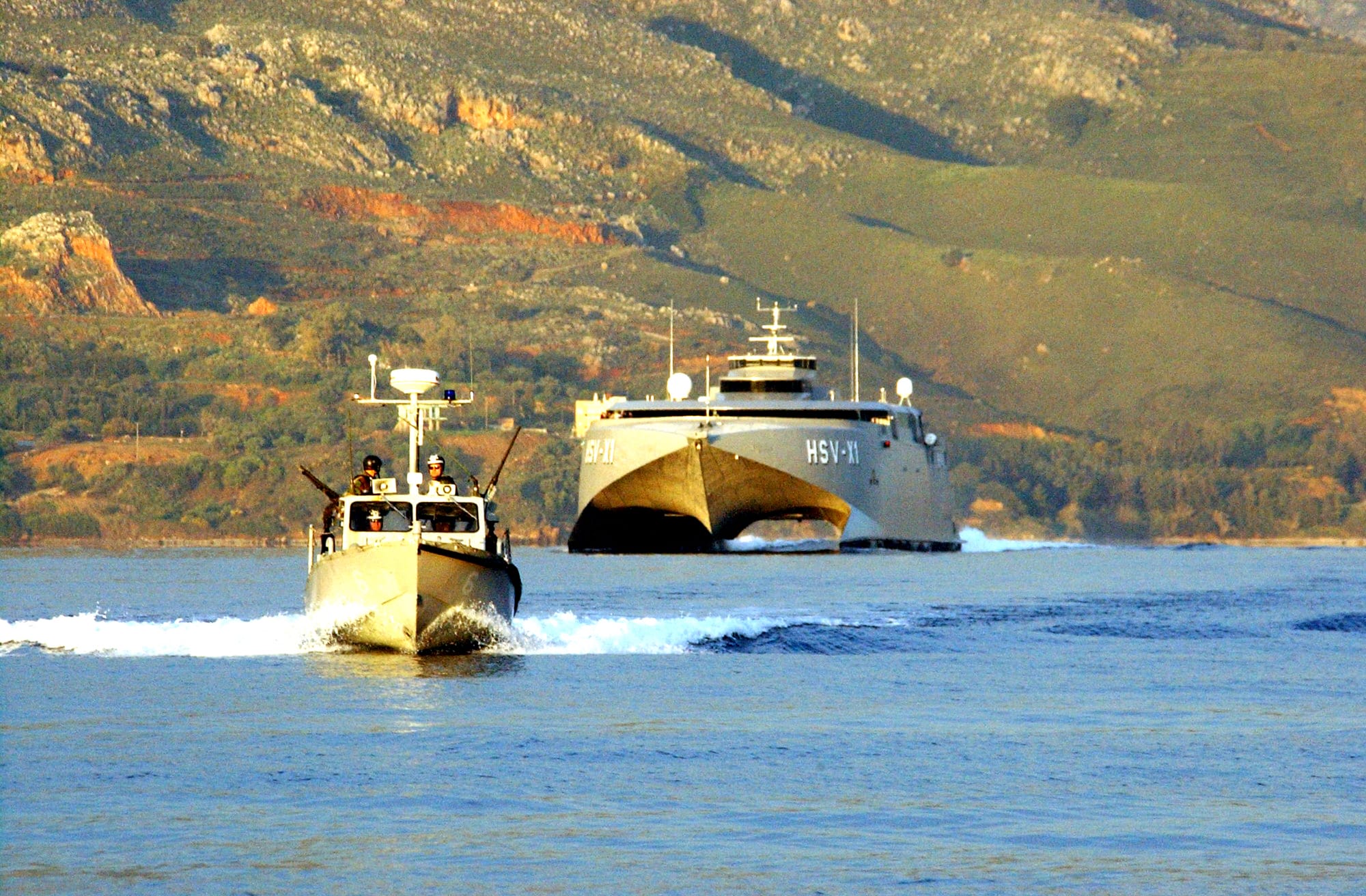 020403-N-0780F-002 Souda Bay, Crete (Apr. 3, 2002) -- The Multi-service high speed vessel, Joint Venture (HSV-X1) pulls into the port of Souda Bay, Crete. The 313 foot-long experimental craft is a wave-piercing catamaran capable of 45 knots and is currently being operated by joint U.S. Army and U.S. Navy personnel. Joint Venture’s naval employment includes replenishment and resupply at sea, special operations insertion and redeployment, reconnaissance, command and control, anti-submarine warfare, mine warfare, humanitarian assistance/evacuation, surface warfare and force protection. U.S. Navy photo by Paul Farley. (RELEASED)